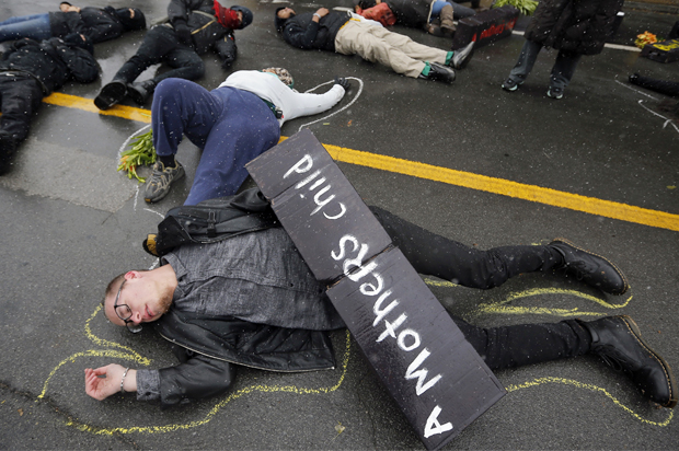 Demonstrators lie on the ground during a protest marking the 100th day since the shooting death of Michael Brown in St. Louis, Missouri November 16, 2014. (Reuters/Jim Young)