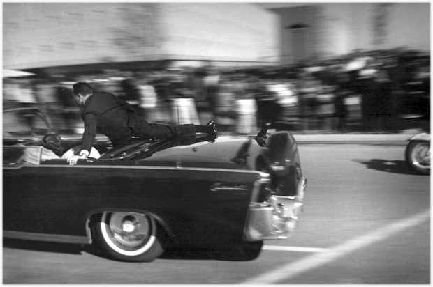 The limousine carrying mortally wounded President John F. Kennedy races toward the hospital seconds after he was shot in Dallas, Nov. 22, 1963. (AP/Justin Newman)