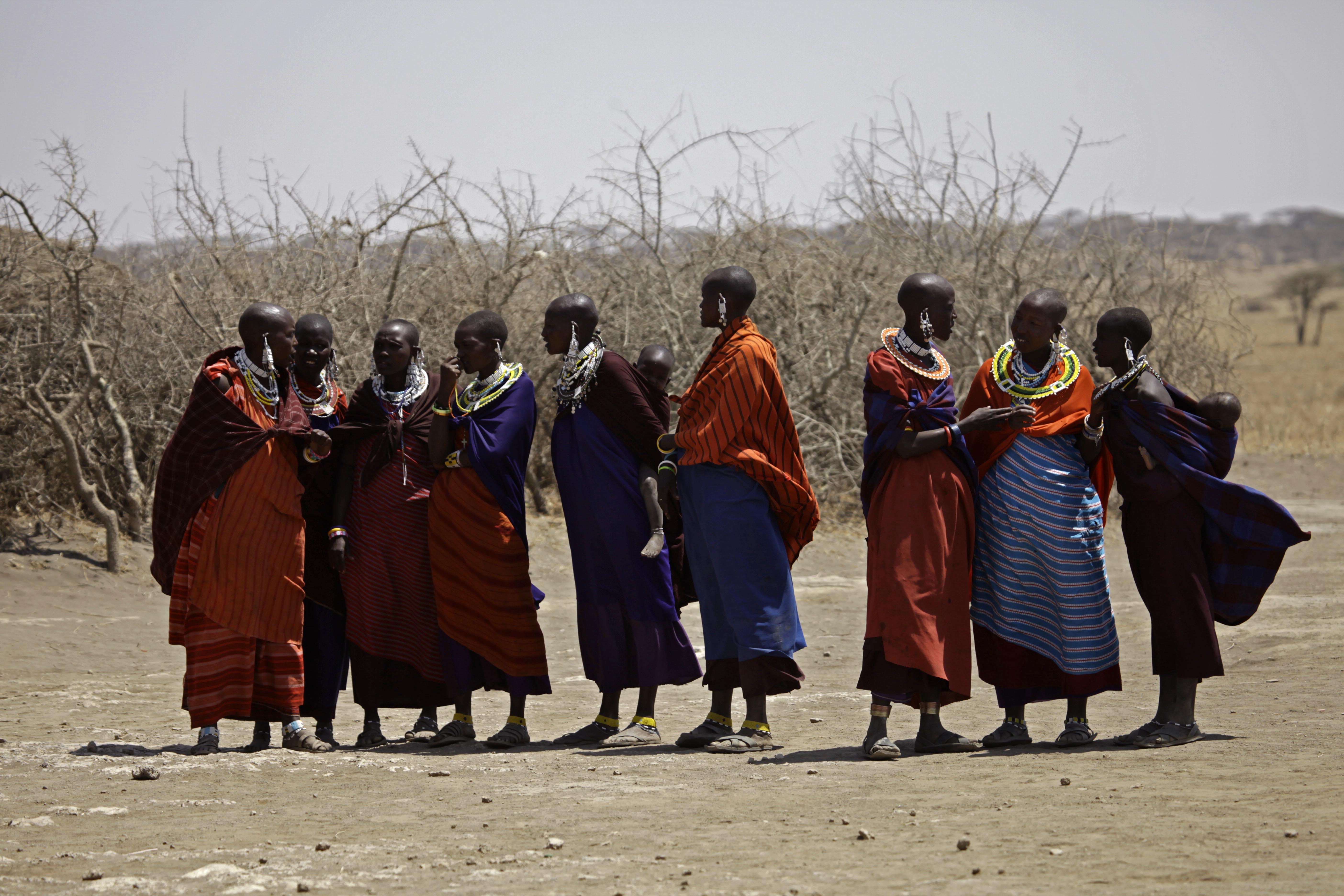 FILE - In this Monday, Aug. 12, 2013 file photo, Maasai tribeswomen gather at a village on the outskirts of the Serengeti, in northern Tanzania. (AP/Nariman El-Mofty)