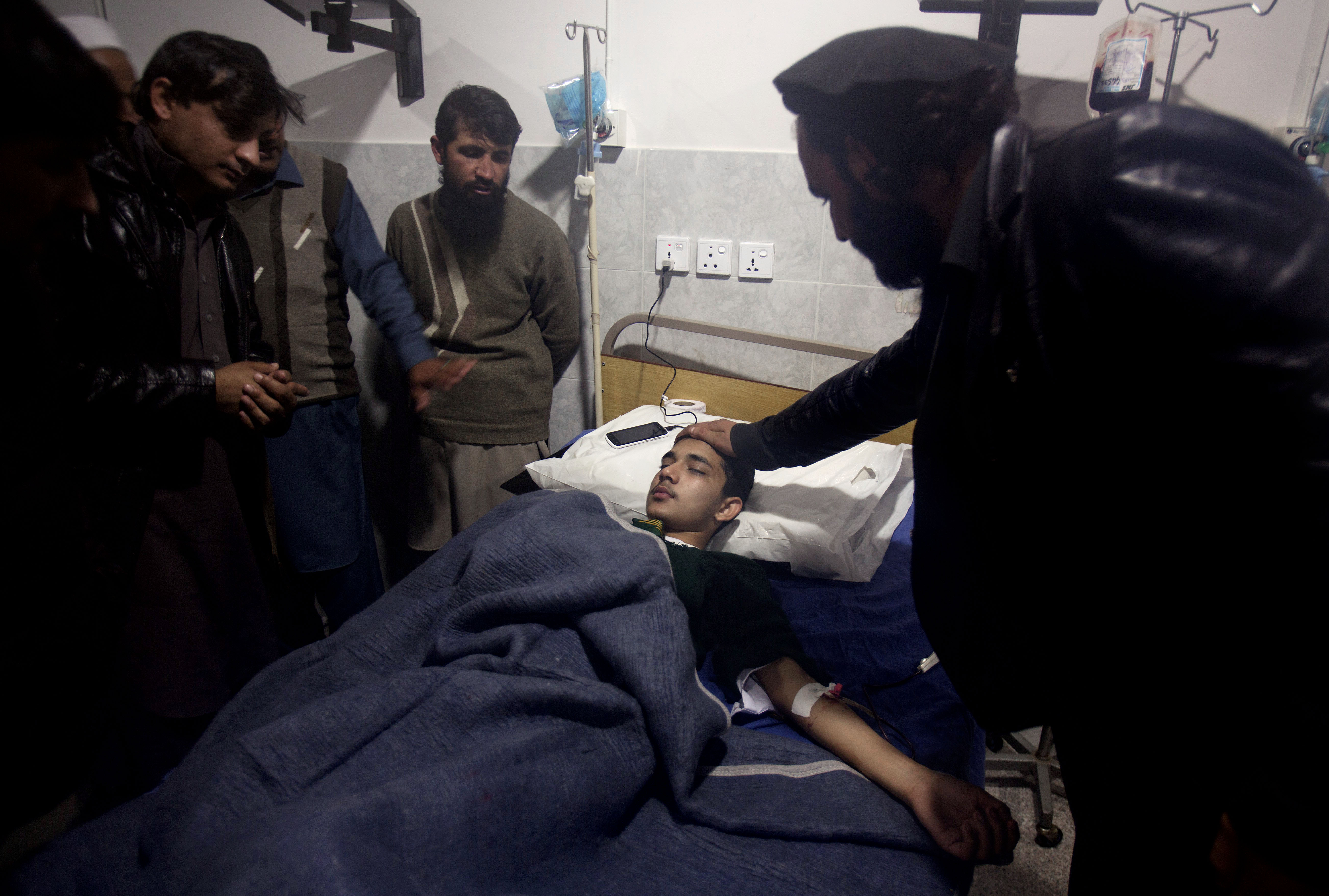 A man comforts a child who survives a Taliban attack on a school that killed more than 100 people, admits at a local hospital in Peshawar, Pakistan, Tuesday, Dec. 16, 2014. Taliban gunmen stormed a military-run school in the northwestern Pakistani city of Peshawar on Tuesday, killing at least 100 people, mostly children, before Pakistani officials declared a military operation to clear the school over. (AP Photo/B.K. Bangash) (AP)