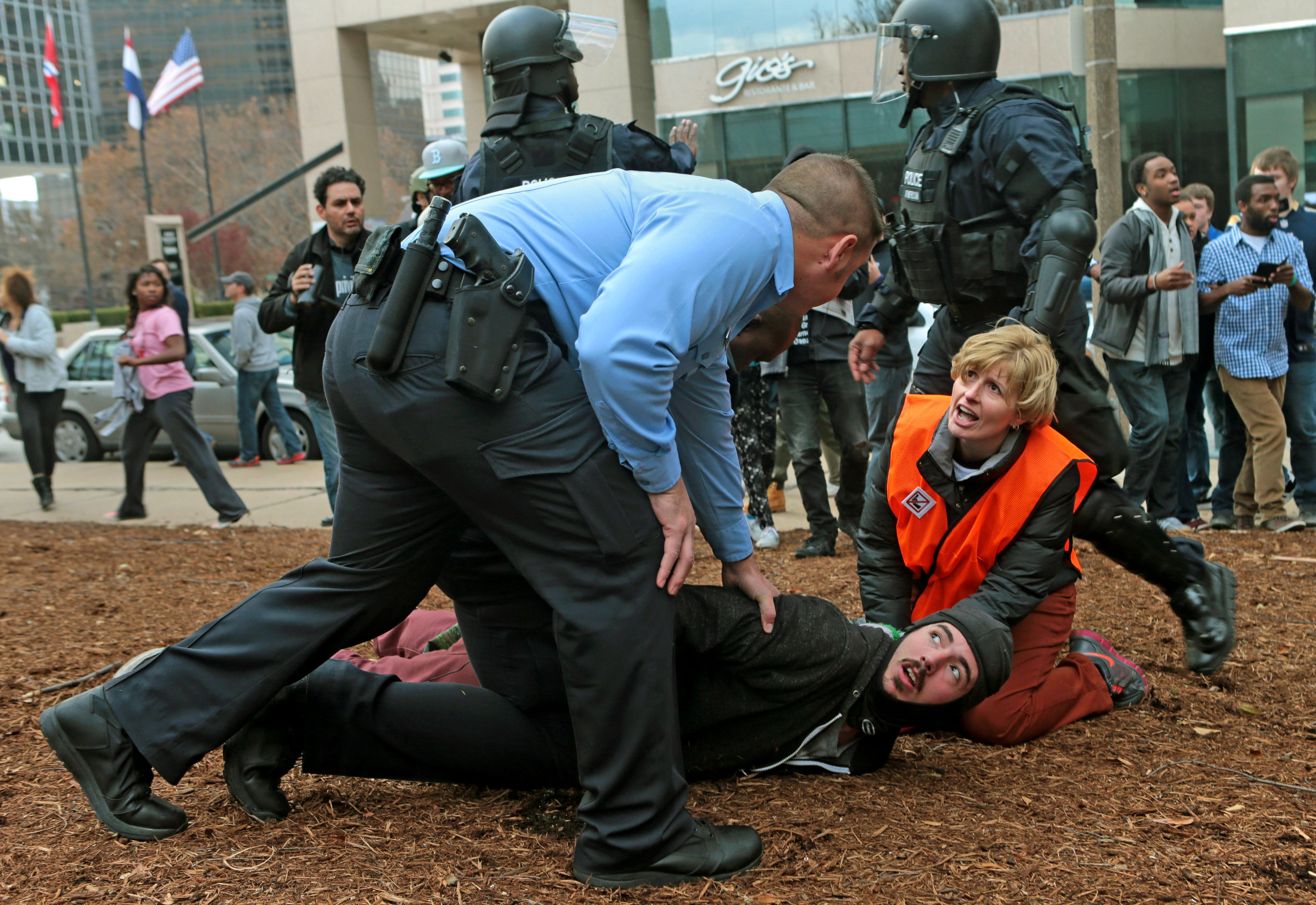 A clergy member assists a protester as he is taken to the ground on Sunday, Nov. 30, 2014, at Kiener Plaza in St. Louis. Protesters and police clashed following an NFL football game between the St. Louis Rams and the Oakland Raiders as protests continued following a grand jury's decision not to indict a Ferguson police officer in the shooting death of Michael Brown. (AP Photo/St. Louis Post-Dispatch, Laurie Skrivan)  EDWARDSVILLE INTELLIGENCER OUT; THE ALTON TELEGRAPH OUT (AP)