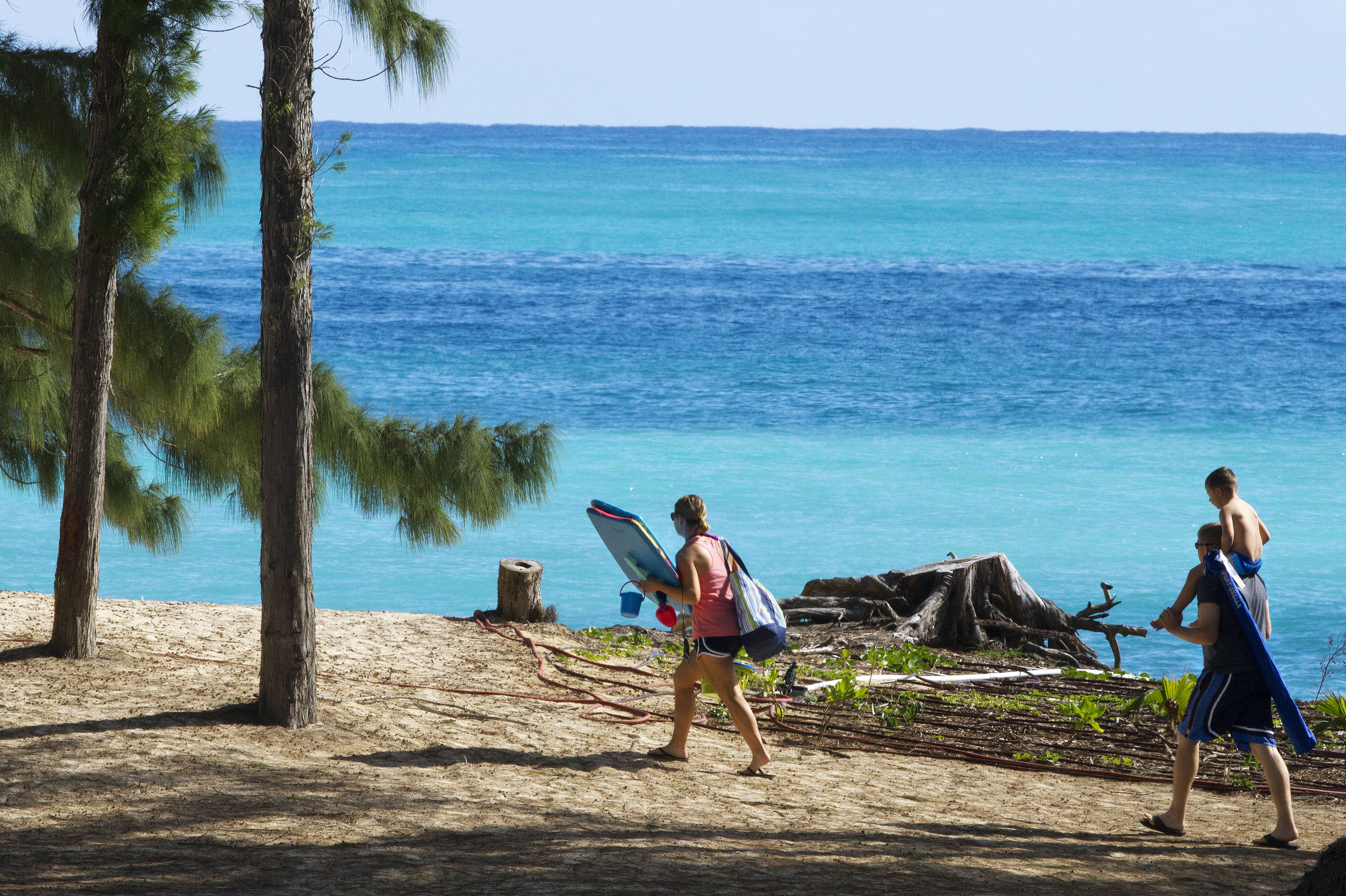 People walk toward the beach near where President Barack Obama and the first family are spending time at Bellows Air Force Station, Hawaii, Friday, Dec. 26, 2014, during the Obama family vacation. (AP Photo/Jacquelyn Martin) (AP)