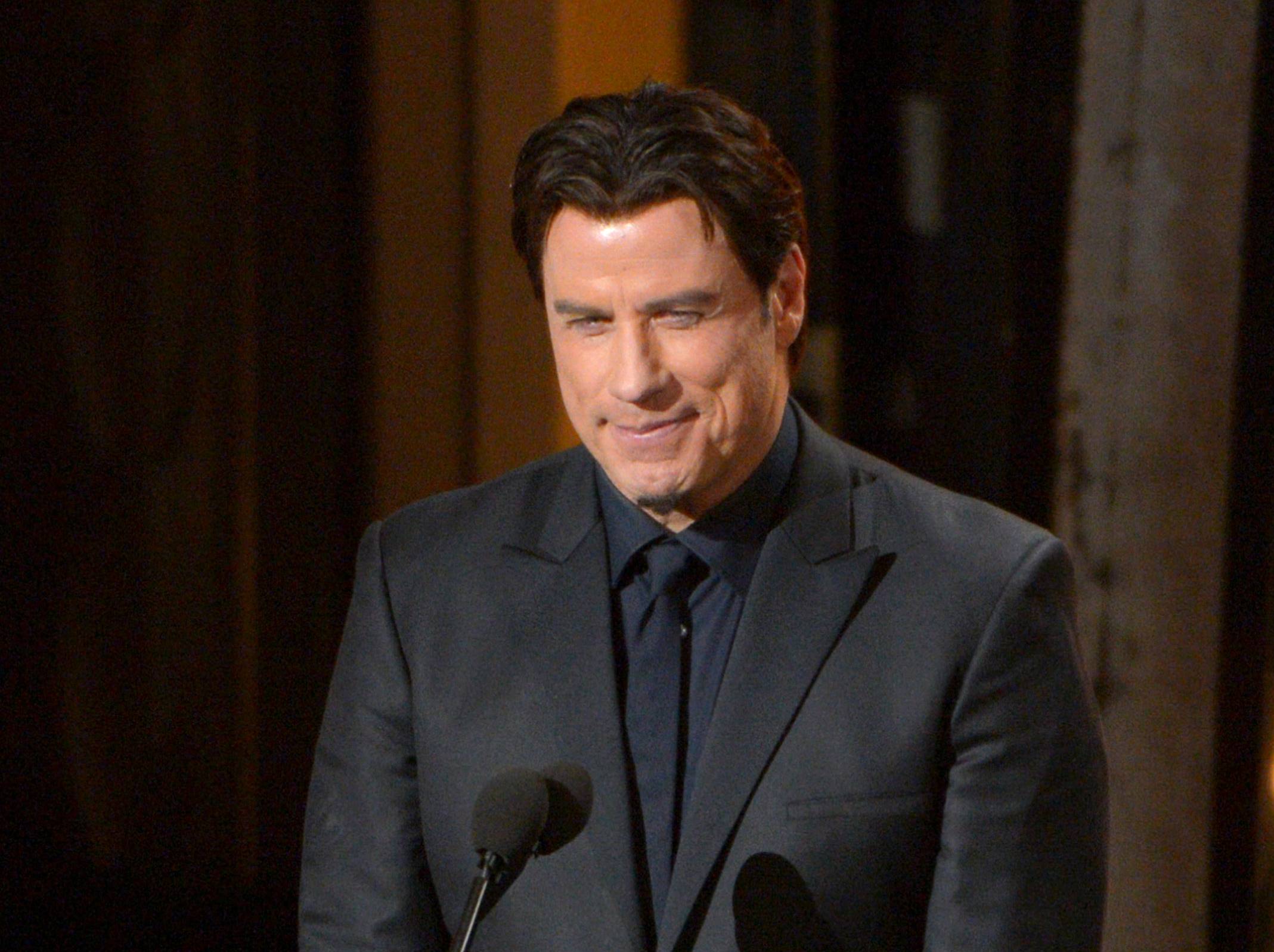 In this March 2, 2014 file photo, presenter John Travolta introduces a performance by Idina Menzel during the Oscars at the Dolby Theatre in Los Angeles. (John Shearer/Invision/AP)