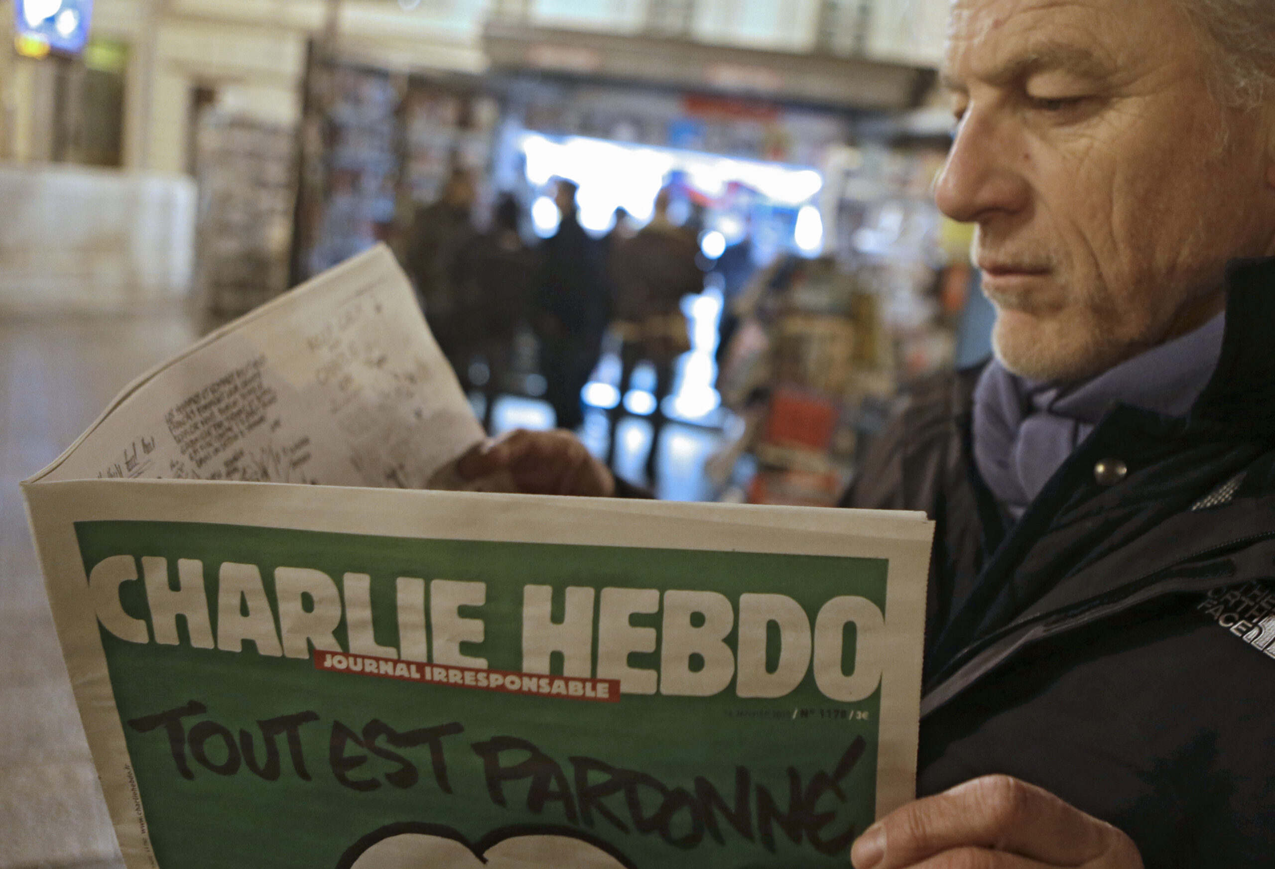 Jean Paul Bierlein reads the new Charlie Hebdo newspapers next a newsstand in Nice, southeastern France, Wednesday, Jan. 14, 2015. (AP Photo/ Lionel Cironneau) (Lionel Cironneau)