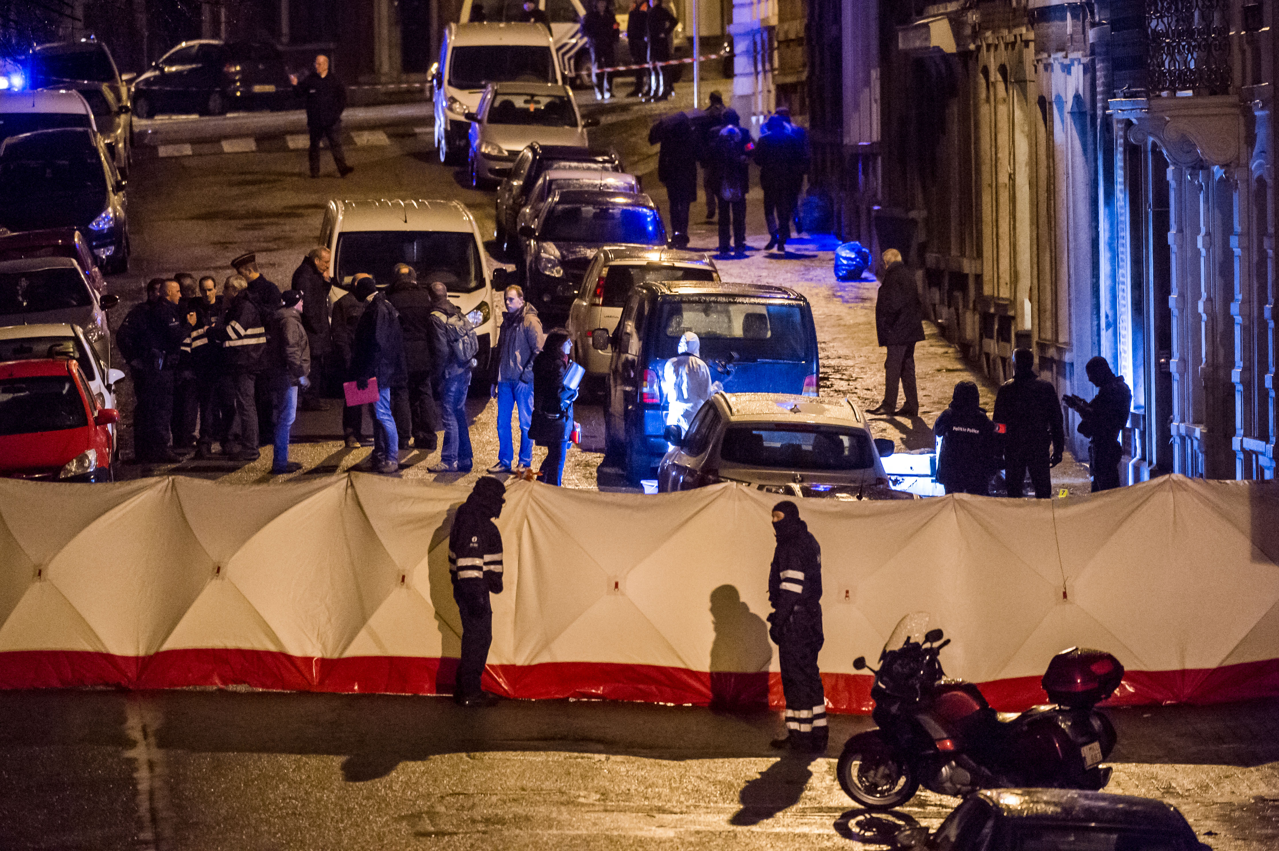 Belgian police officers gather behind a screen as they investigate a a shootout in an anti-terrorist raid in a street in Verviers, Belgium, Thursday, Jan. 15, 2015. Belgian authorities say two people have been killed and one has been arrested during a shootout in an anti-terrorist operation in the eastern city of Verviers. (AP Photo/Geert Vanden Wijngaert) (AP)