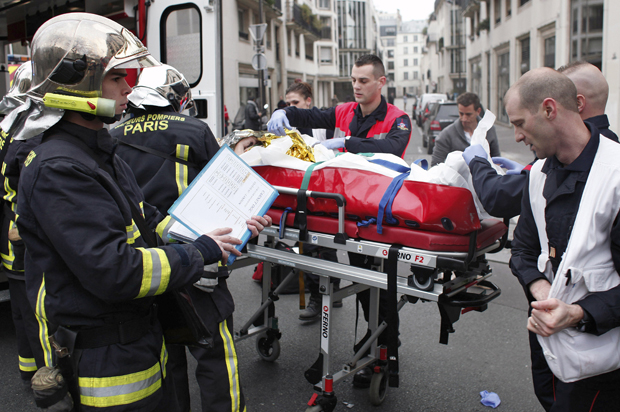 An injured person is carried into an ambulance at the French satirical newspaper Charlie Hebdo's office, in Paris, Jan. 7, 2015. (AP/Thibault Camus)