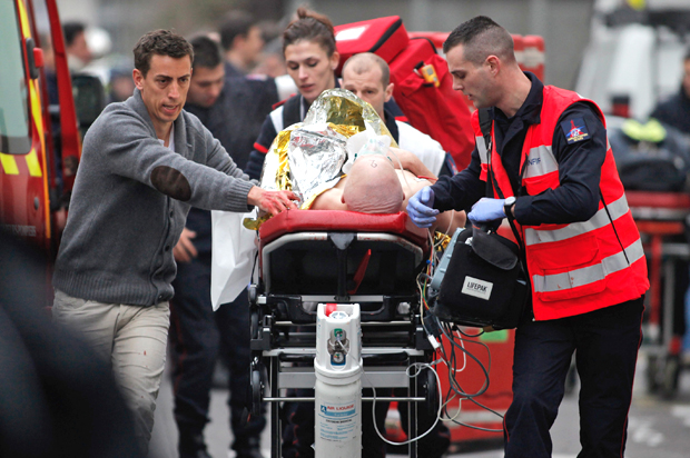 An injured person is transported to an ambulance after a shooting at the French satirical newspaper Charlie Hebdo's office, in Paris, Jan. 7, 2015. (AP/Thibault Camus)
