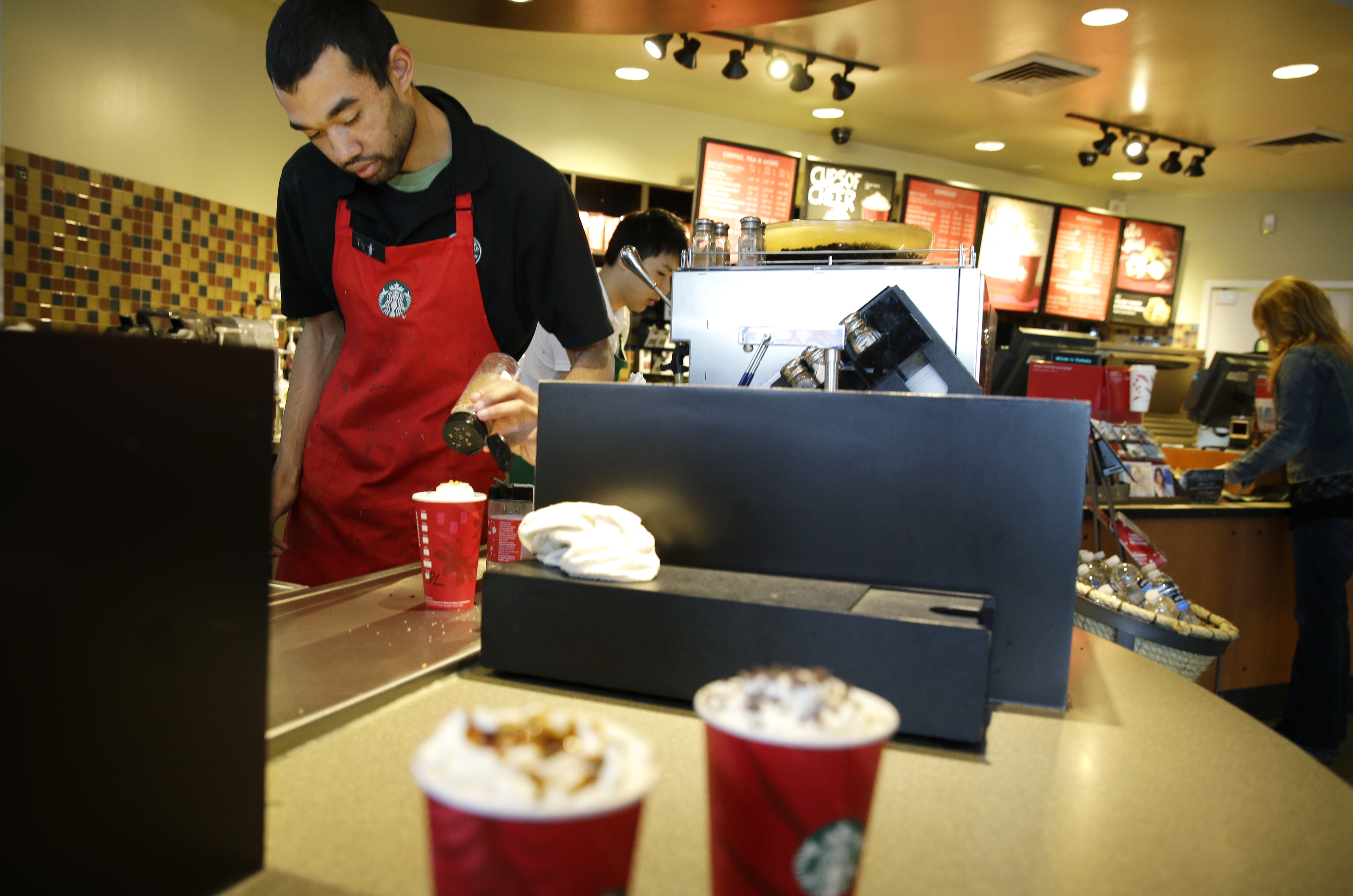 In this Nov. 24, 2014 photo, barista Jay Rapp prepares a Chestnut Praline Latte at a Starbucks store in Seattle. (AP Photo/Ted S. Warren) (AP)