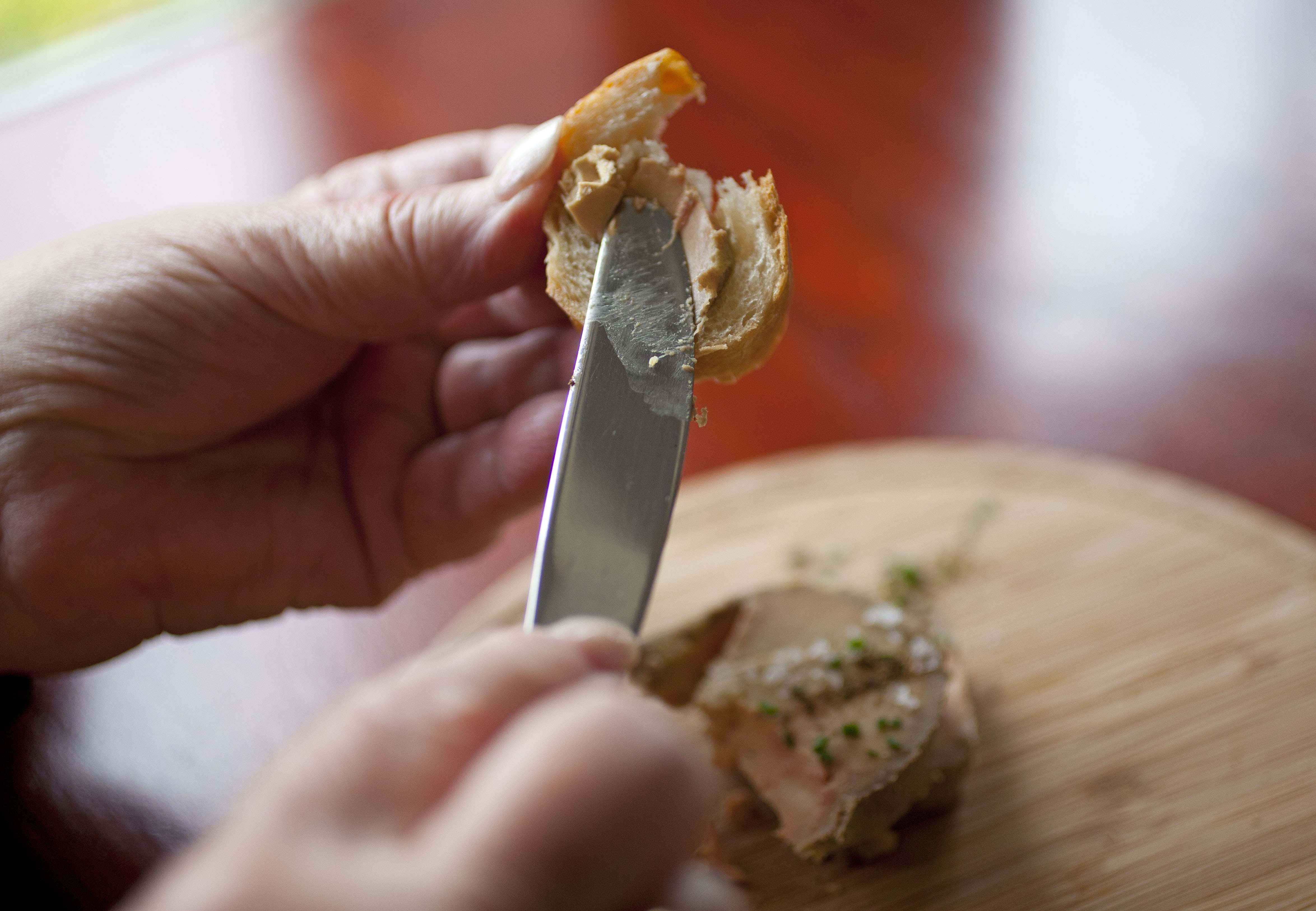 File - This July 17, 2012 file photo shows Karlene Bley of Los Angeles spread her torchon of foie gras onto bread during lunch at the Presidio Social Club restaurant in San Francisco. (AP Photo/Eric Risberg, File) (AP)