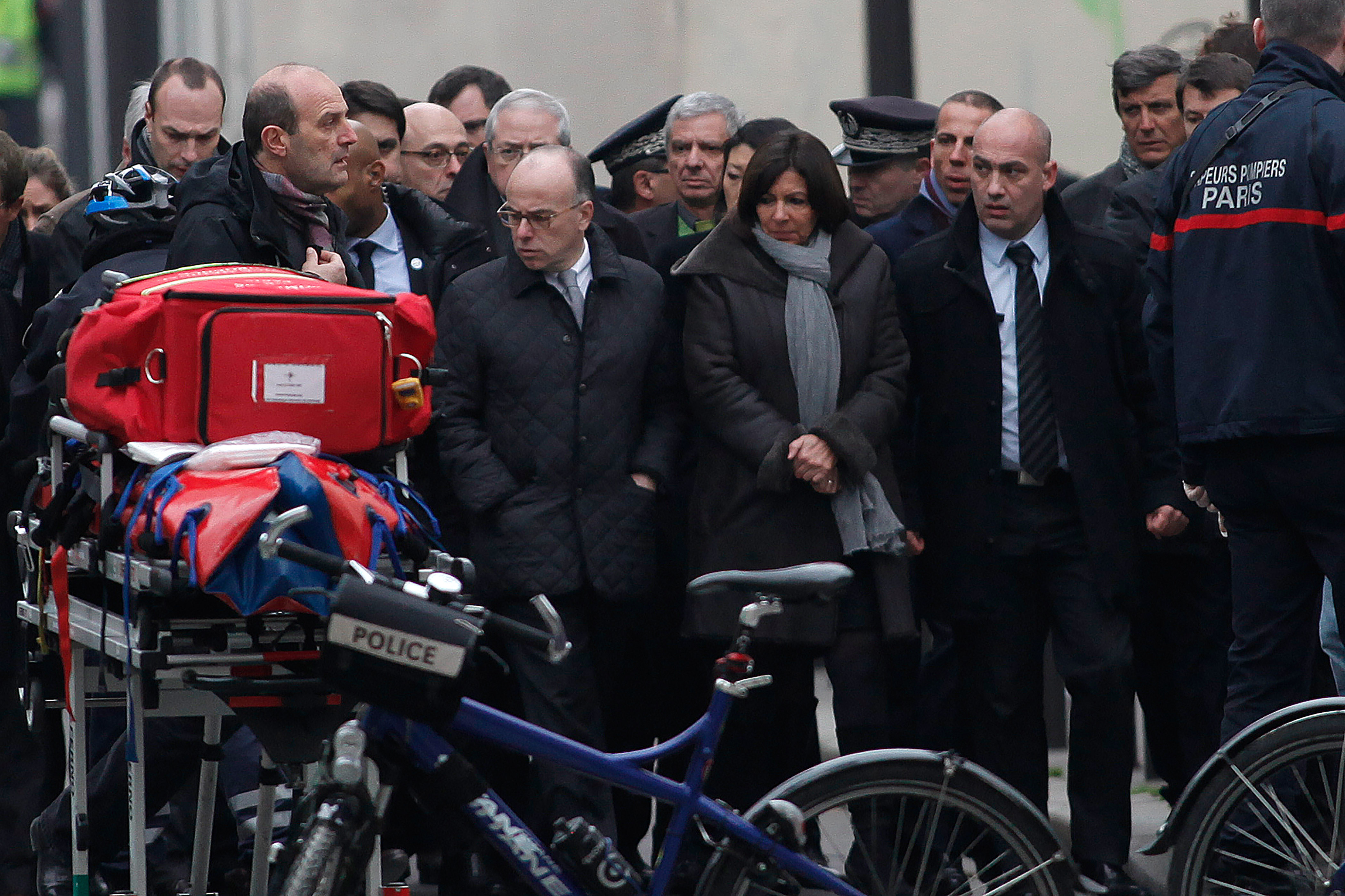French Interior Minister Bernard Cazeneuve, center left, and Paris' mayor Anne Hidalgo, center right, arrive at the French satirical newspaper Charlie Hebdo's office, in Paris, Wednesday, Jan. 7, 2015. Masked gunmen stormed the offices of a French satirical newspaper Wednesday, killing at least 11 people before escaping, police and a witness said. The weekly has previously drawn condemnation from Muslims. (AP Photo/Thibault Camus)