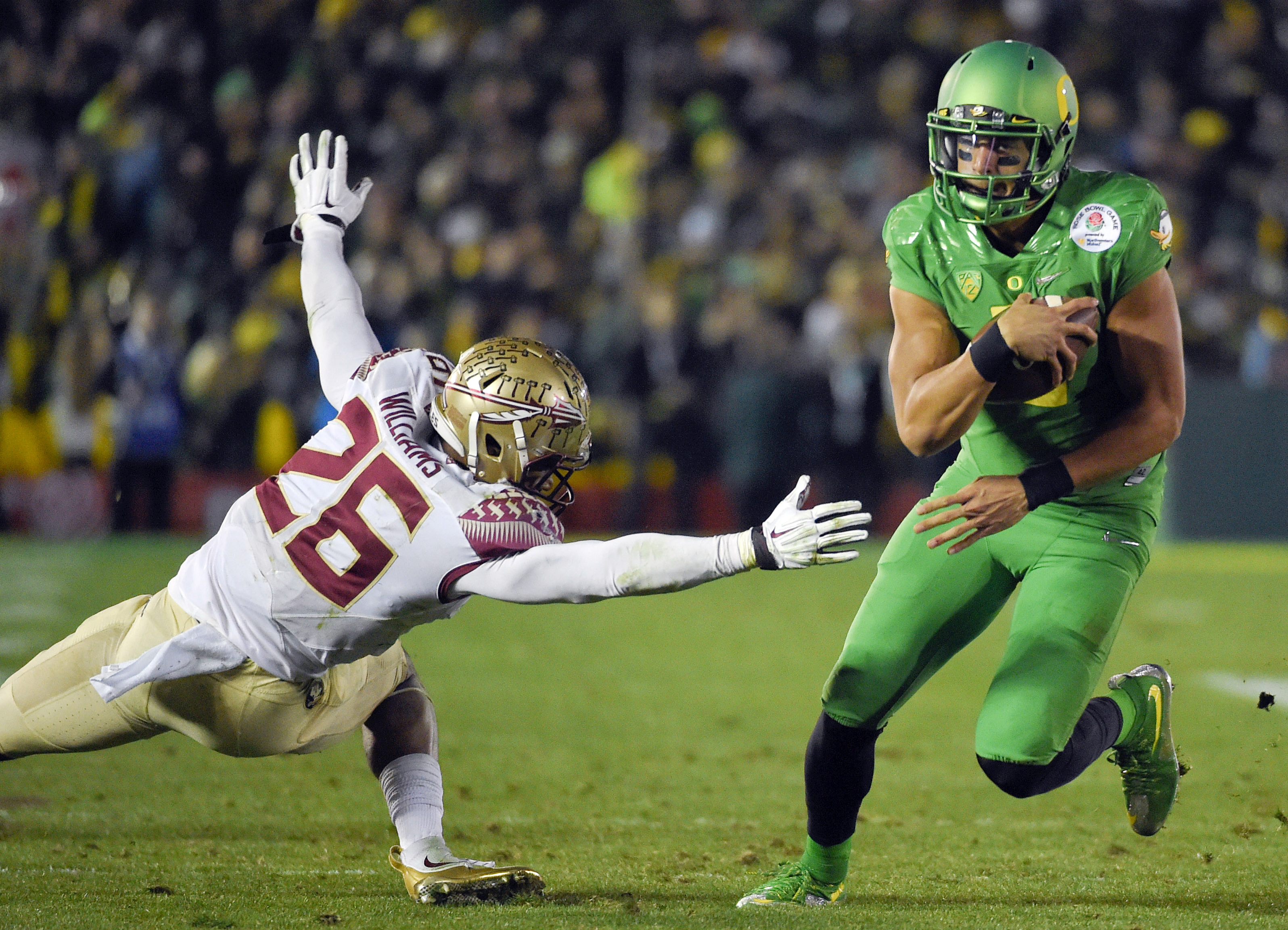 Oregon quarterback Marcus Mariota, right, scores past Florida State defensive back P.J. Williams during the second half of the Rose Bowl NCAA college football playoff semifinal, Thursday, Jan. 1, 2015, in Pasadena, Calif. (AP Photo/Mark J. Terrill) (AP)
