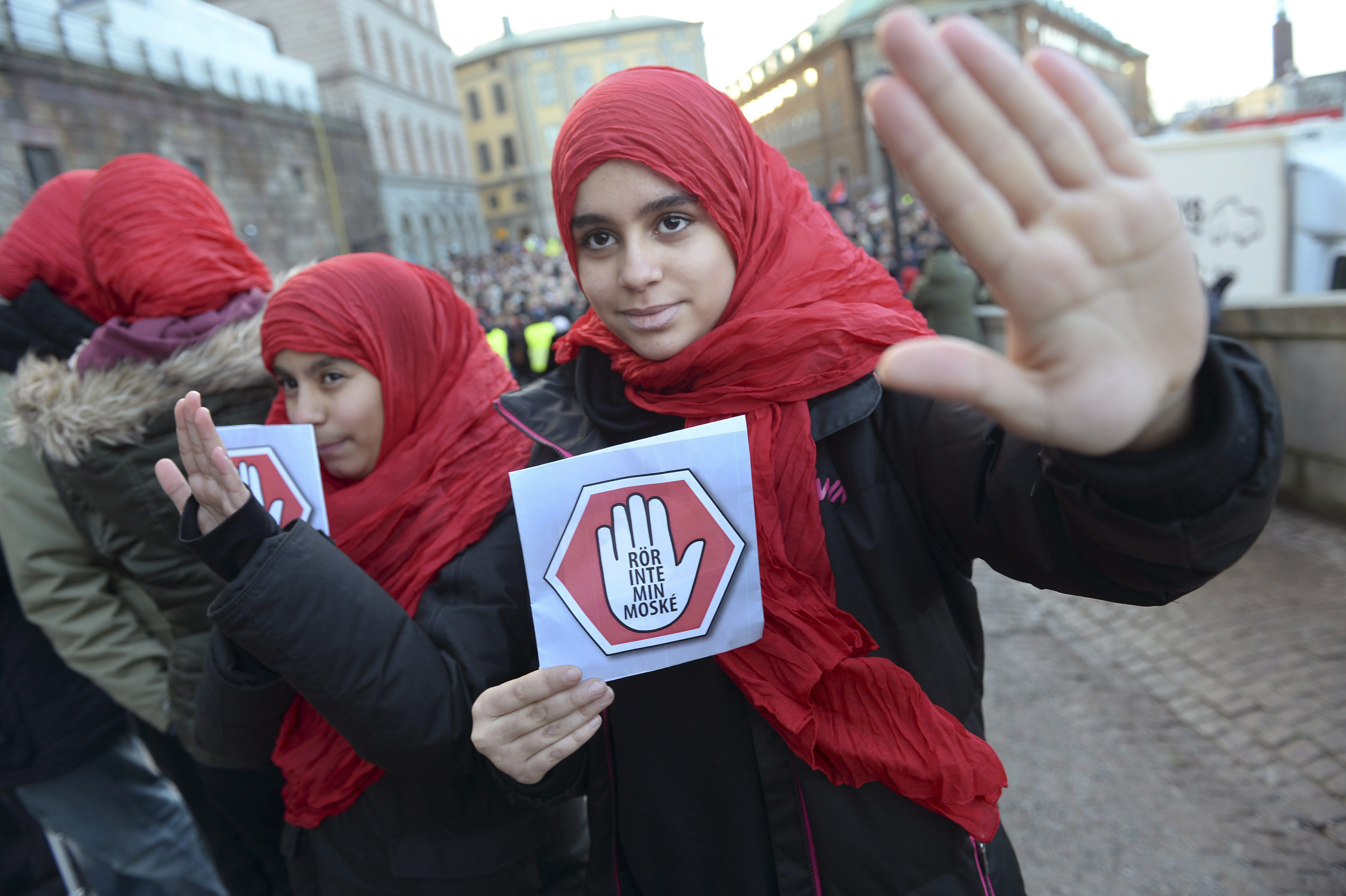 Two young girls carrying leaflets saying "don't touch my mosque" participate in a demonstration at the  parliament in Stockholm on Friday  Jan. 2, 2015. Three mosques have suffered arson attacks in Sweden since Christmas Day. (AP Photo/Fredrik Sandberg) SWEDEN OUT (AP)