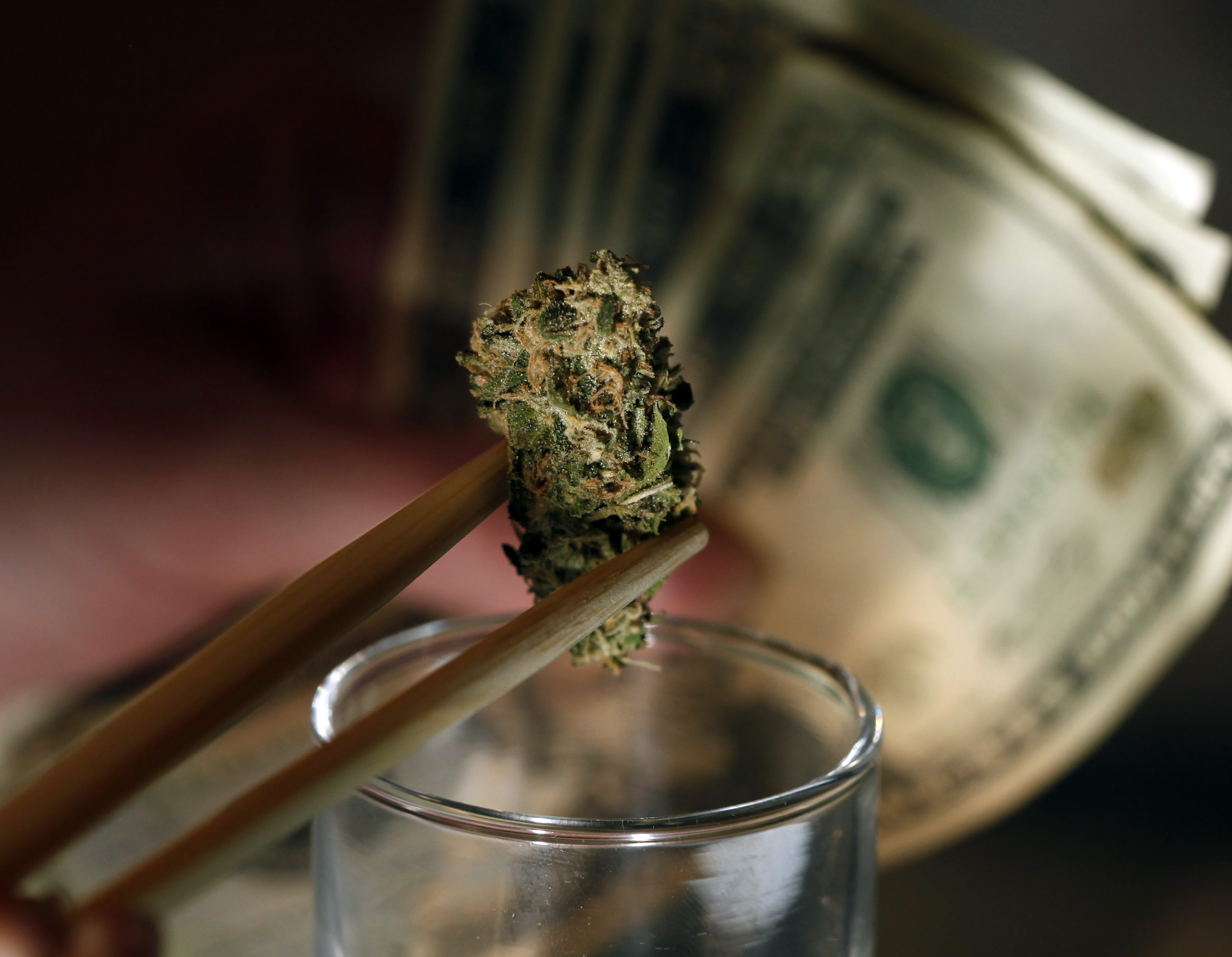 In this Sept. 18, 2012, file photo a caregiver picks out a marijuana bud for a patient at a marijuana dispensary in Denver. (AP/Ed Andrieski)