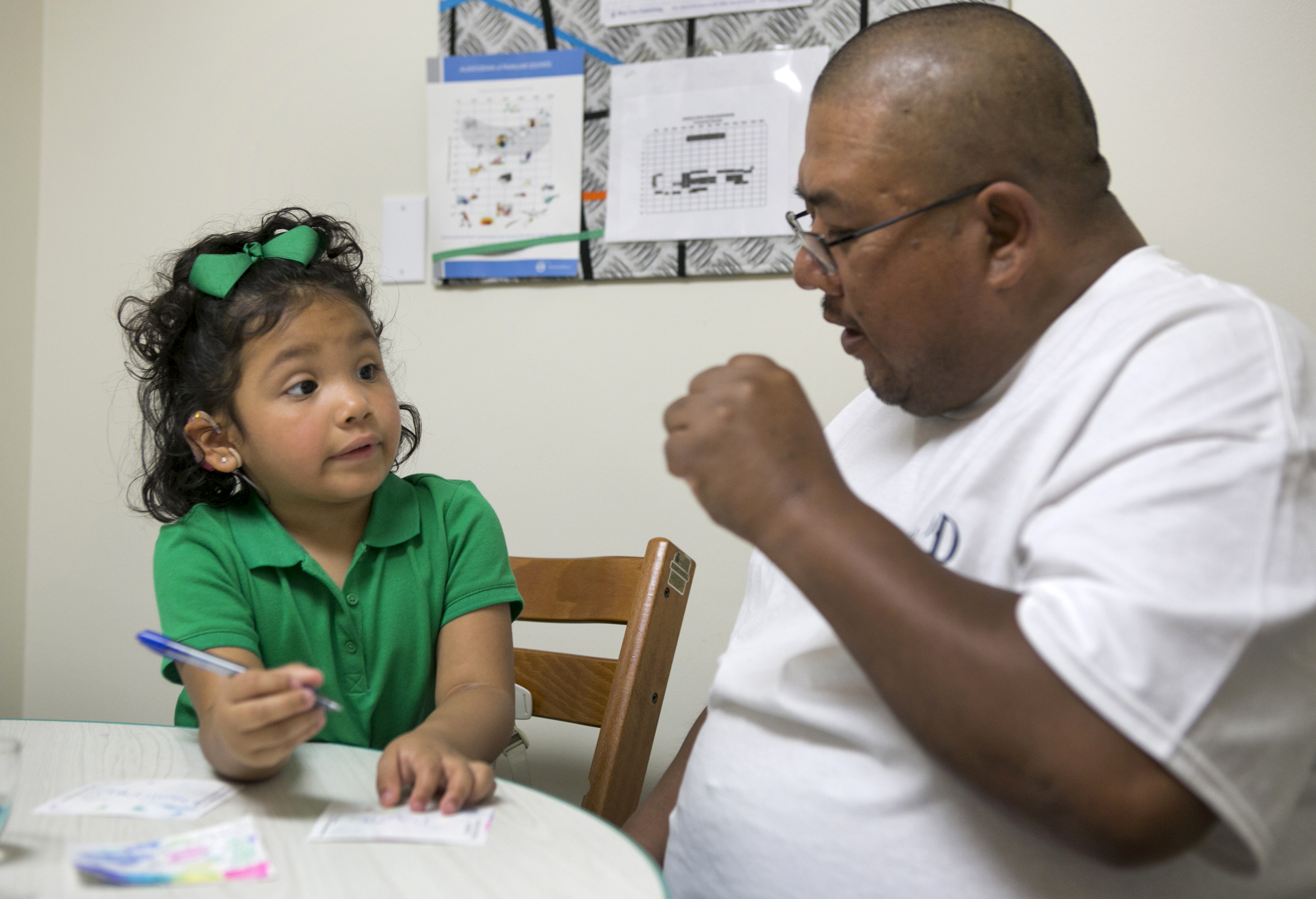 In this photo taken Feb. 11, 2015, Angelica Lopez, 3, writes her name with the help of her father, Santos Lopez, during a therapy session at the University of Southern California in Los Angeles. Angelica was born deaf and received an auditory brainstem implant to allow her to hear some sounds as part of a research study into the devices' use in young children. (AP Photo/Damian Dovarganes) (AP)
