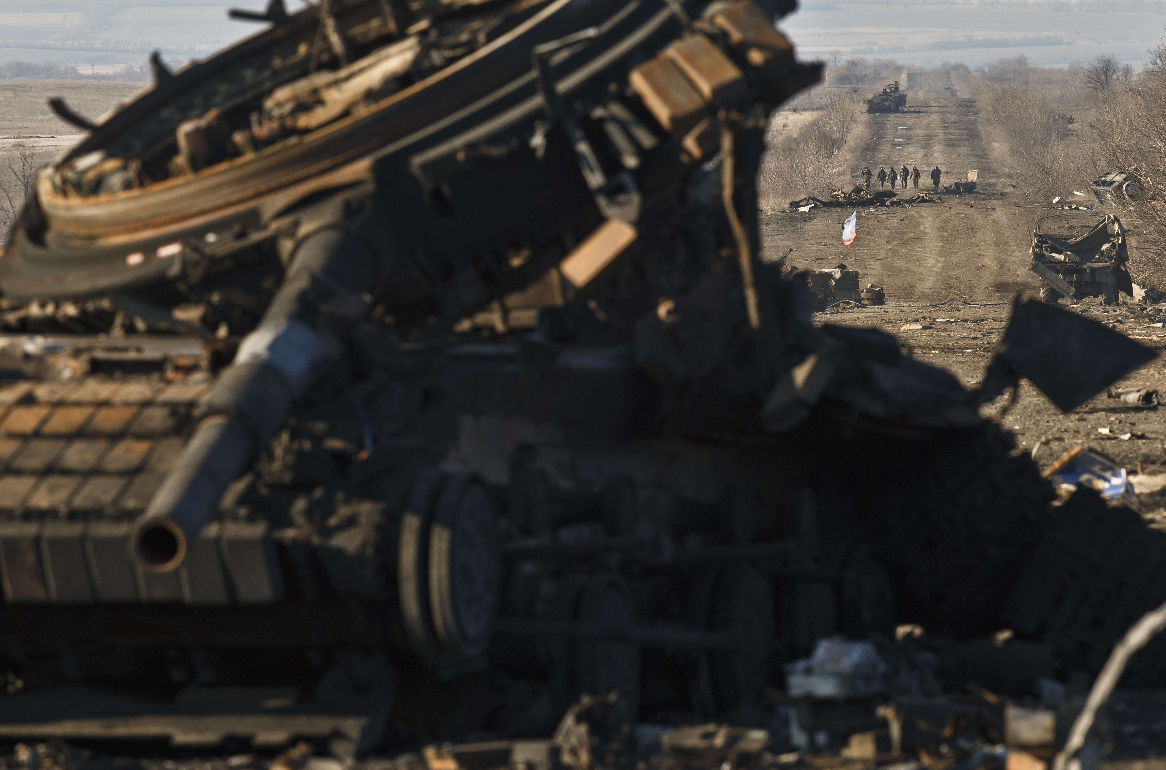 FILE - In this Sunday Feb. 22, 2015 file photo, Russia-backed separatists walk along a road that takes them to Artemivsk, littered with destroyed Ukrainian army tanks and vehicles, outside Debaltseve, Ukraine. (AP Photo/Vadim Ghirda, File) (AP)