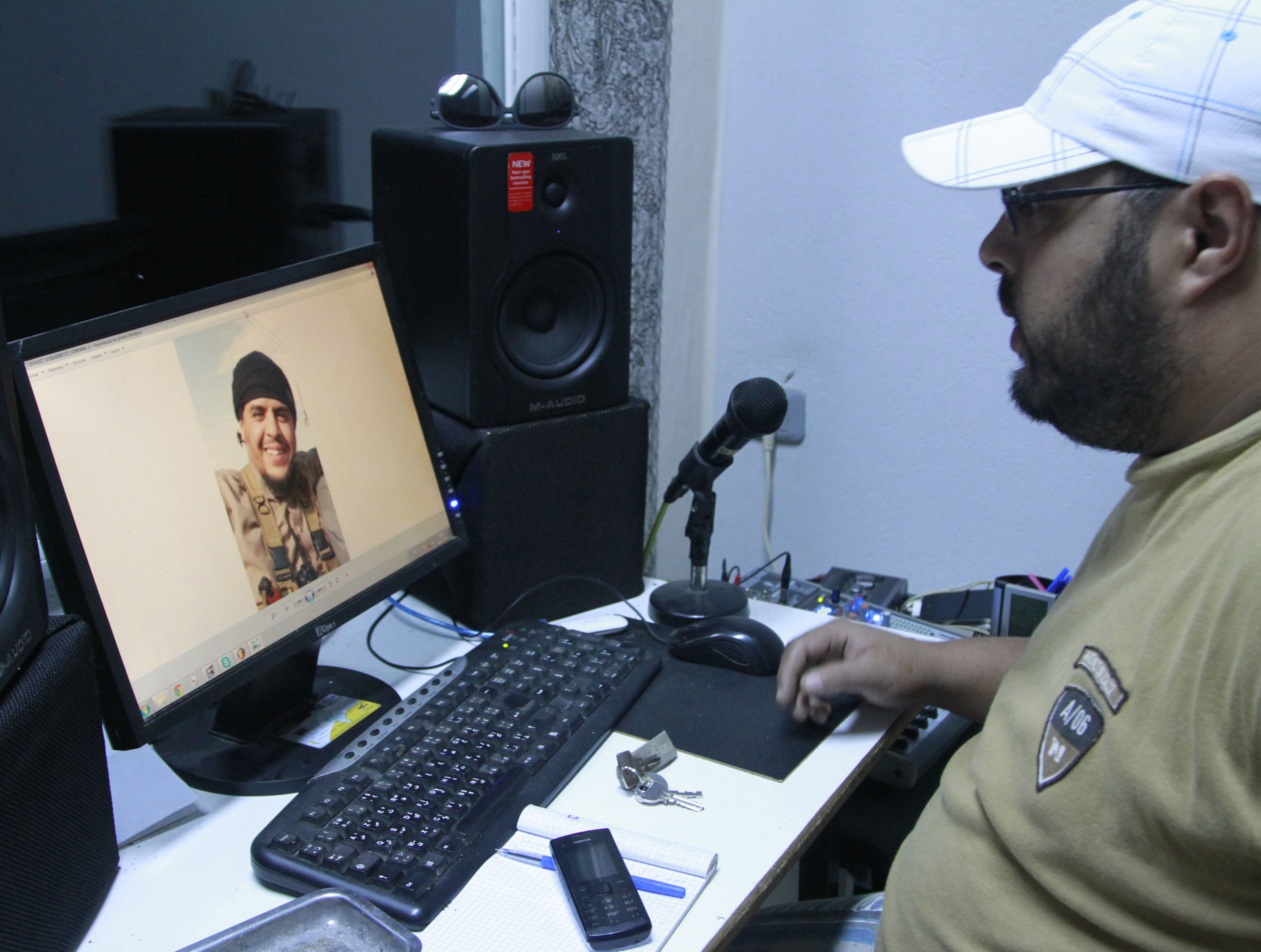 In this Dec. 4, 2014 photo, Mehdi "DJ Costa" Akkari, a Tunisian rapper, looks at an image of his brother Youssef, who fought with extremists in Syria and was killed by a U.S. airstrike, in Tunis, Tunisia. While foreigners from across the world have joined the Islamic State militant group, some arrive in Iraq or Syria only to find day-to-day life much more austere and violent than they had expected. (AP Photo/Paul Schemm) (AP)