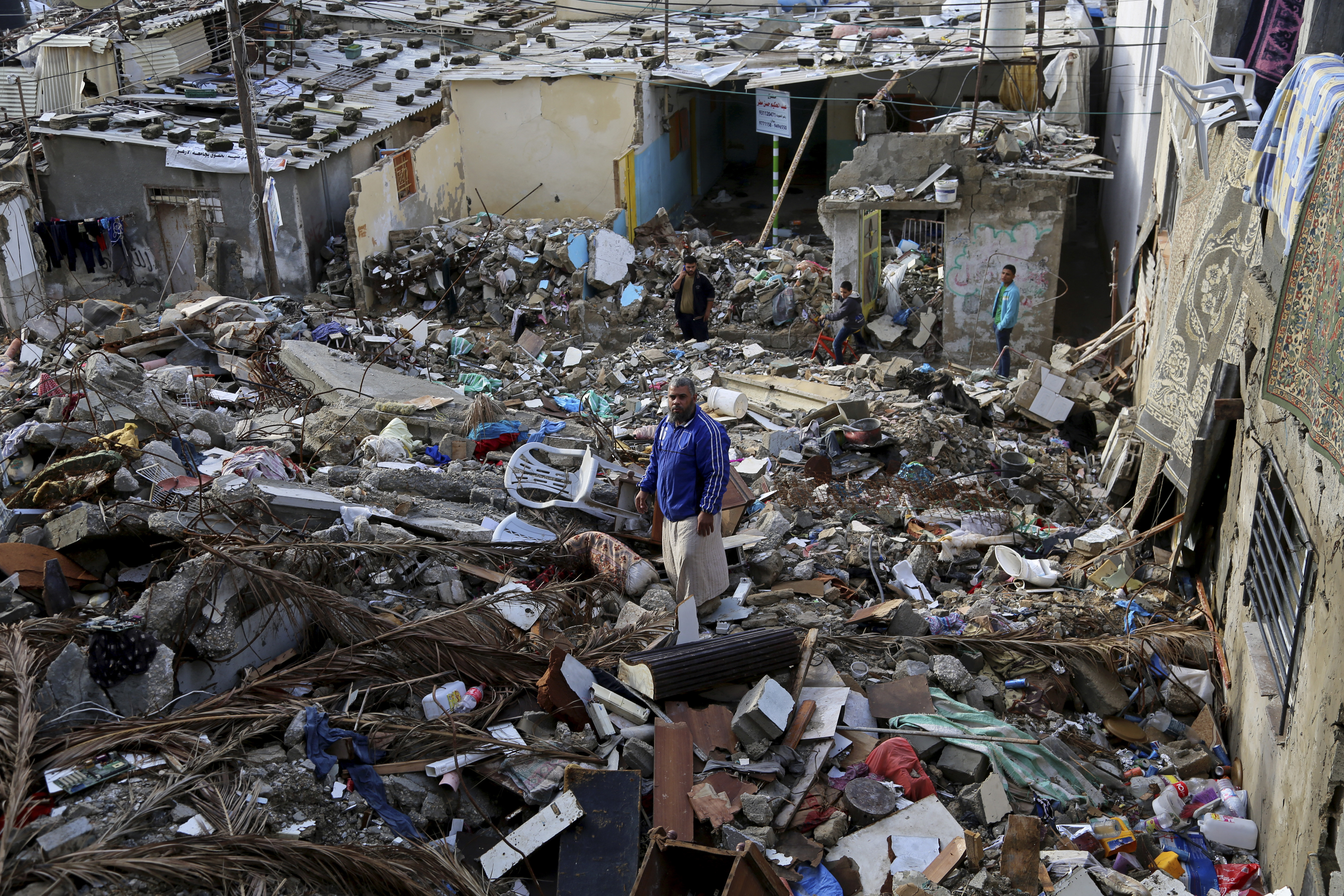 In this Tuesday, Nov. 25, 2014 photo, Mohammed al-Bakri, stands on the rubble of his family home in the Shati refugee camp in Gaza. The Aug. 4 airstrike killed six people, five of them relatives. Two of those killed were members of the militant group Islamic Jihad. Israel carried out scores of attacks on houses during its summer war with Gaza militants, alleging militants used them for military purposes. Palestinians say Israel's warplanes often struck without regard for civilians. (AP Photo/Adel Hana) (AP)