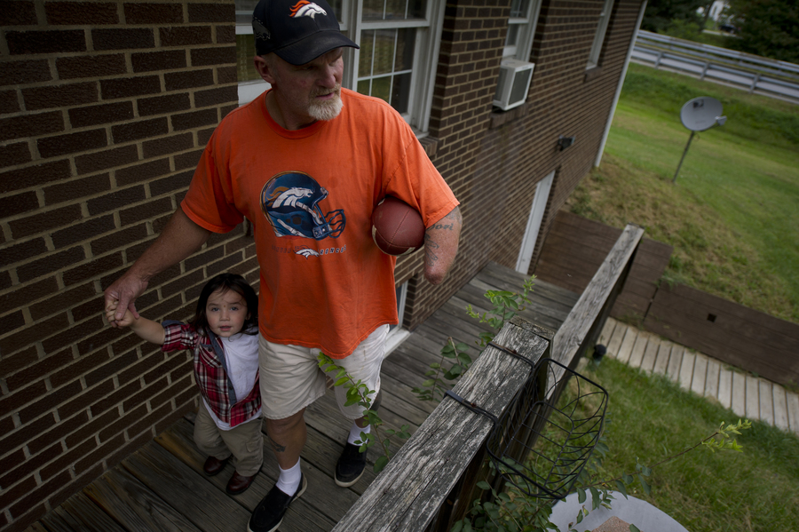 Despite the setbacks he’s faced with his injury and workers’ comp, Dennis Whedbee has tried to maintain an active life, waking early for yard sales, cooking homemade spaghetti sauce and throwing a football with his grandsons. Here, he walks his grandson Haven, 2, back inside their home in Homer City, Pennsylvania.(Jeff Swensen for ProPublica) (Jeff Swensen For Propublica)