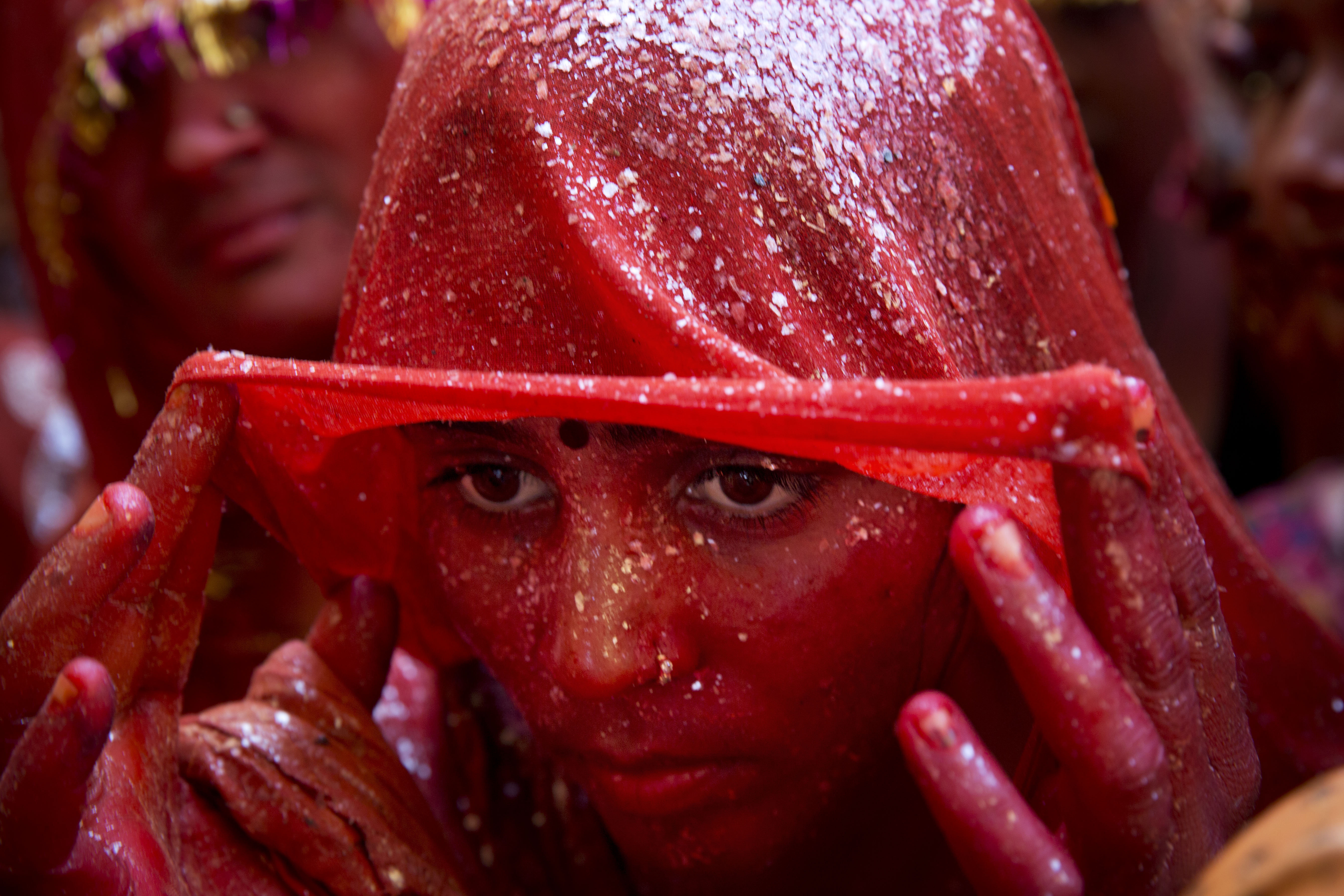 AP10ThingsToSee - A Hindu woman devotee lifts her veil as she stands drenched in colored water during "Huranga," celebrated as part of Holi, the Hindu festival of colors, at the Baldev Temple in Dauji, 180 kilometers (113 miles) south of New Delhi, India, Saturday, March 7, 2015.   (AP Photo/Bernat Armangue) (AP)