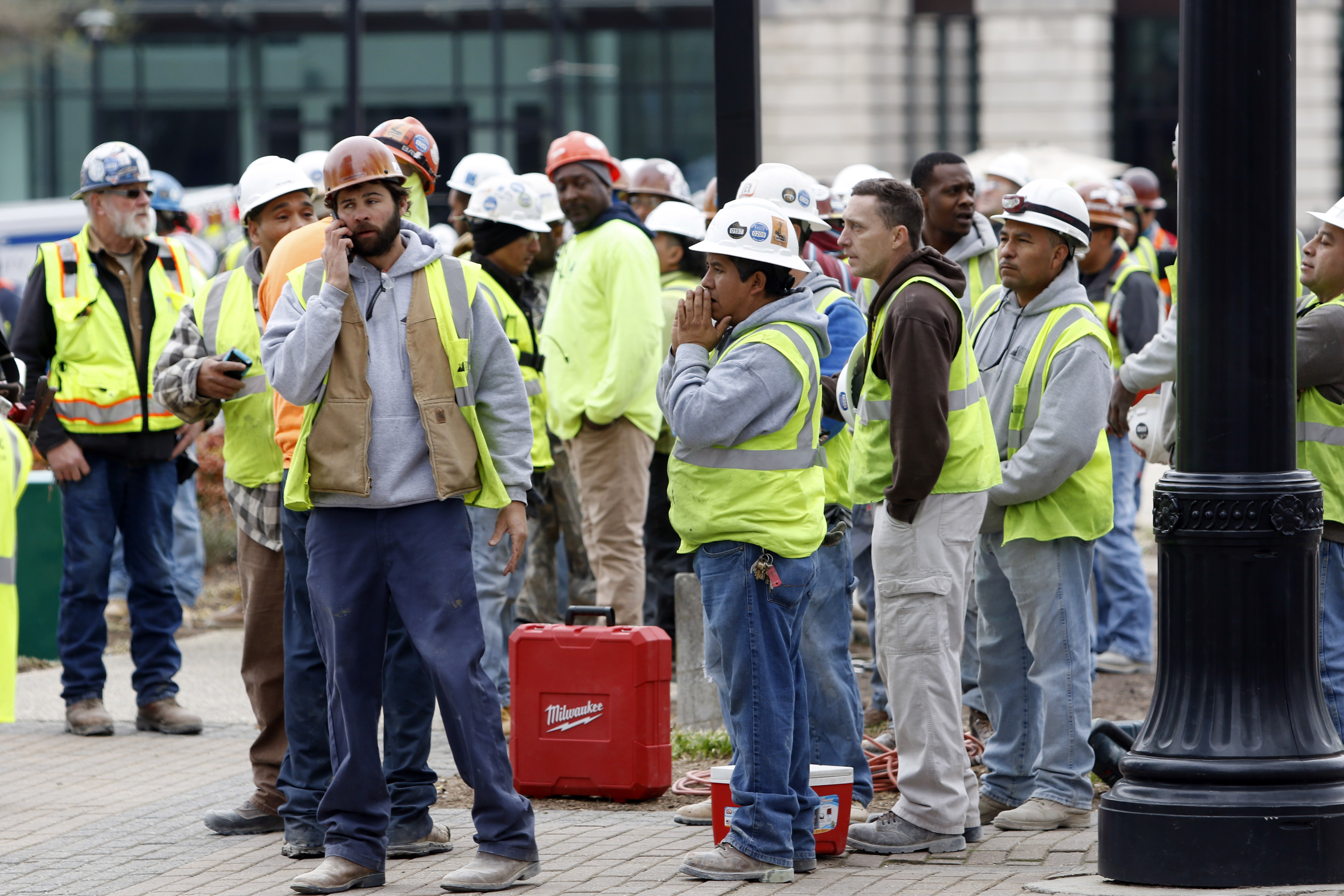 Construction workers gather outside the scene where a section of scaffolding collapsed at a high-rise construction project, killing three people and sending another to a hospital, Monday, March 23, 2015, in downtown Raleigh, N.C. (AP Photo/The News & Observer, Harry Lynch) (AP)