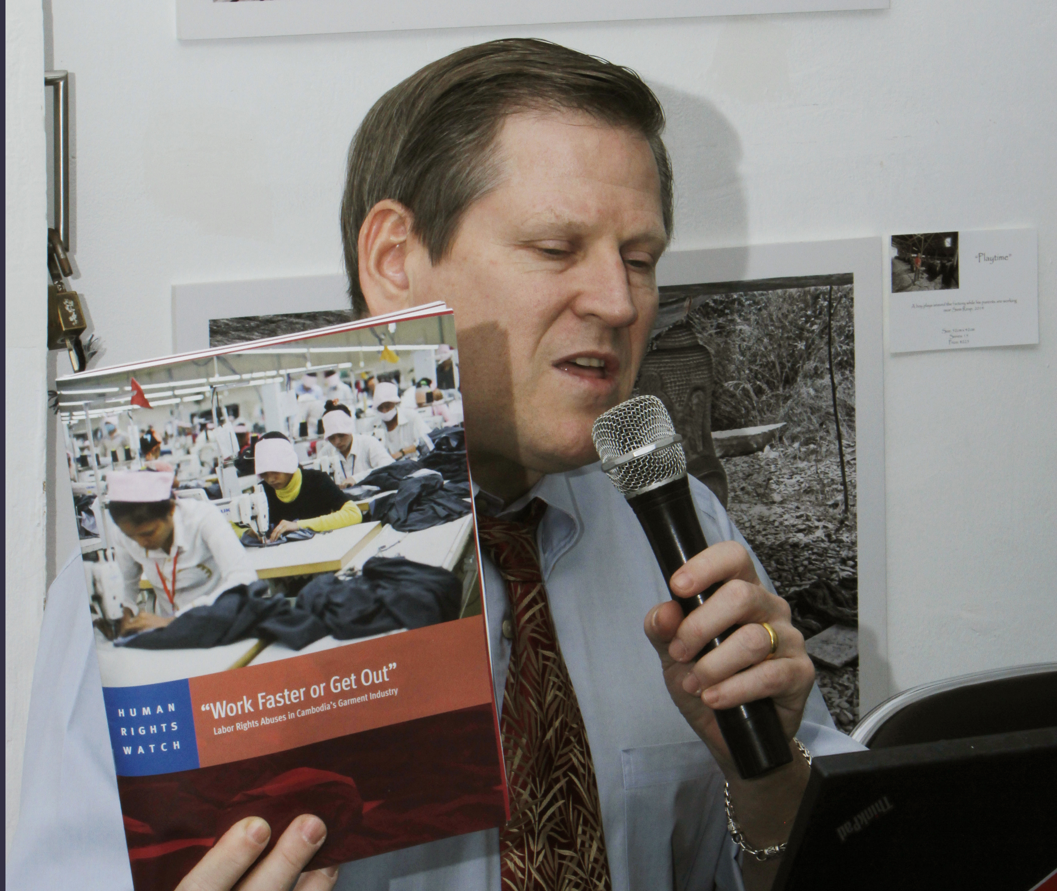 Phil Robertson, deputy director of Human Rights Watch's Asia division, speaks while showing its report during a press conference in Phnom Penh, Cambodia Thursday, March 12, 2015. Leading clothing retailers such as Gap and H&M need to help alleviate labor abuses at factories in Cambodia that manufacture their products, the New York-based human rights organization said. (AP Photo/Heng Sinith) (Heng Sinith)
