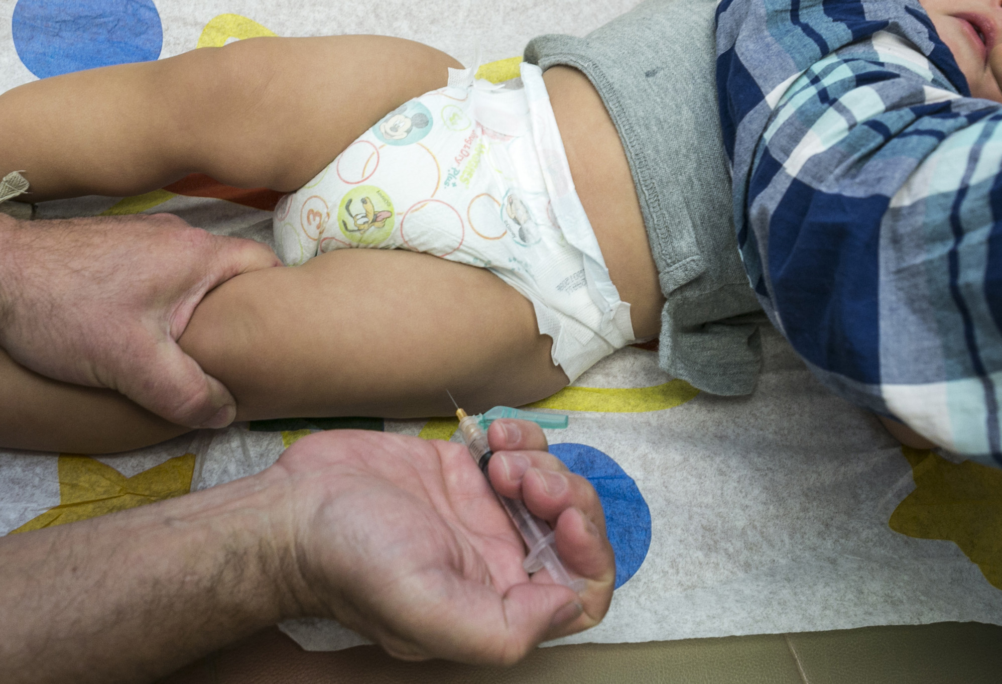 FILE - In this Jan. 29, 2015 file photo, a pediatrician uses a syringe to vaccinate a 1-year-old with the measles-mumps-rubella (MMR) vaccine in Northridge, Calif. (AP Photo/Damian Dovarganes, File)