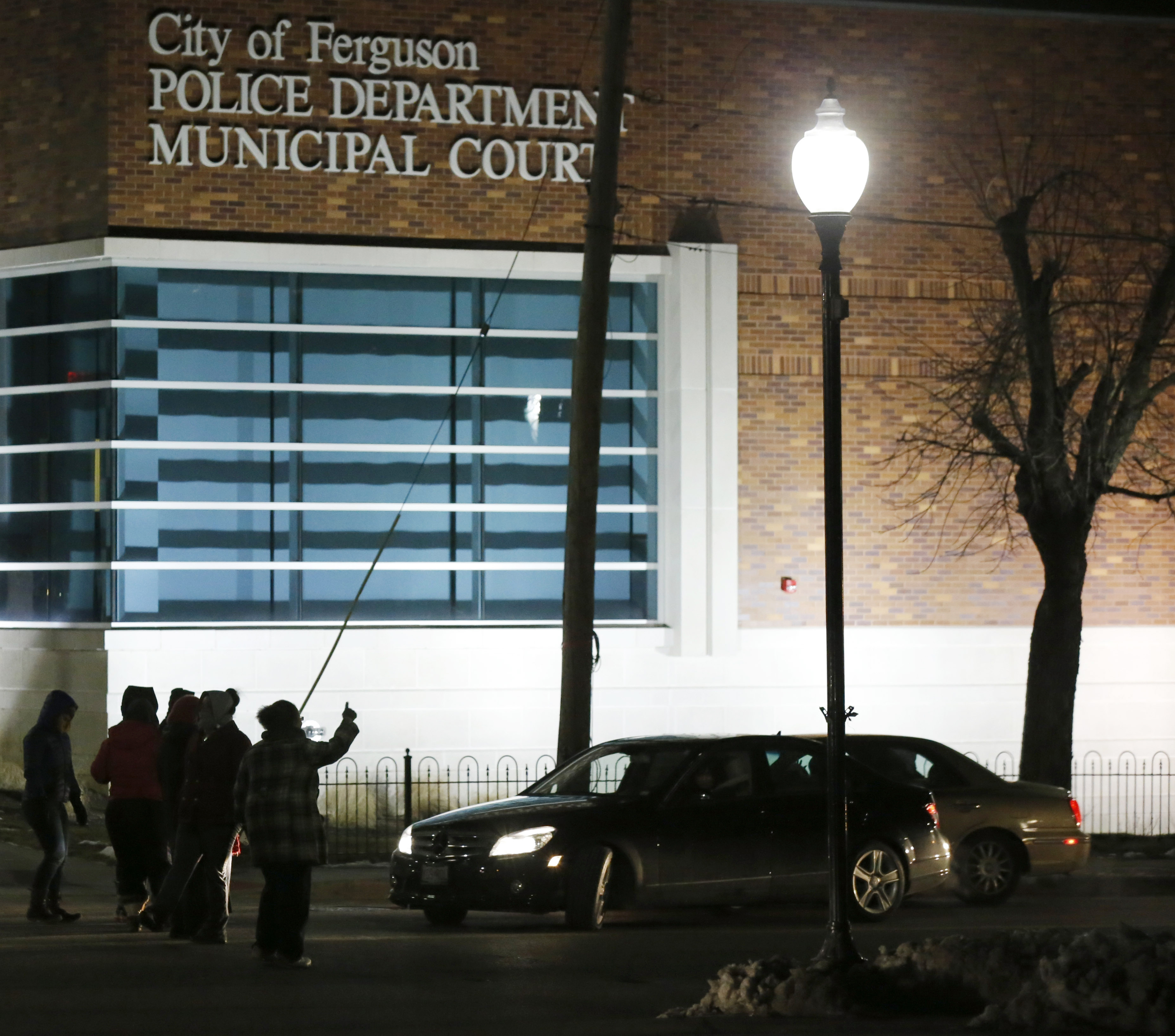 FILE - In this March 4, 2015, file photo, protesters block traffic on the street outside the Ferguson, Mo., police department in Ferguson. The Justice Department on Wednesday cleared a white former Ferguson police officer in the fatal shooting of an unarmed black 18-year-old, but also issued a scathing report calling for sweeping changes in city law enforcement practices it called discriminatory and unconstitutional. (AP/Charles Rex Arbogast)