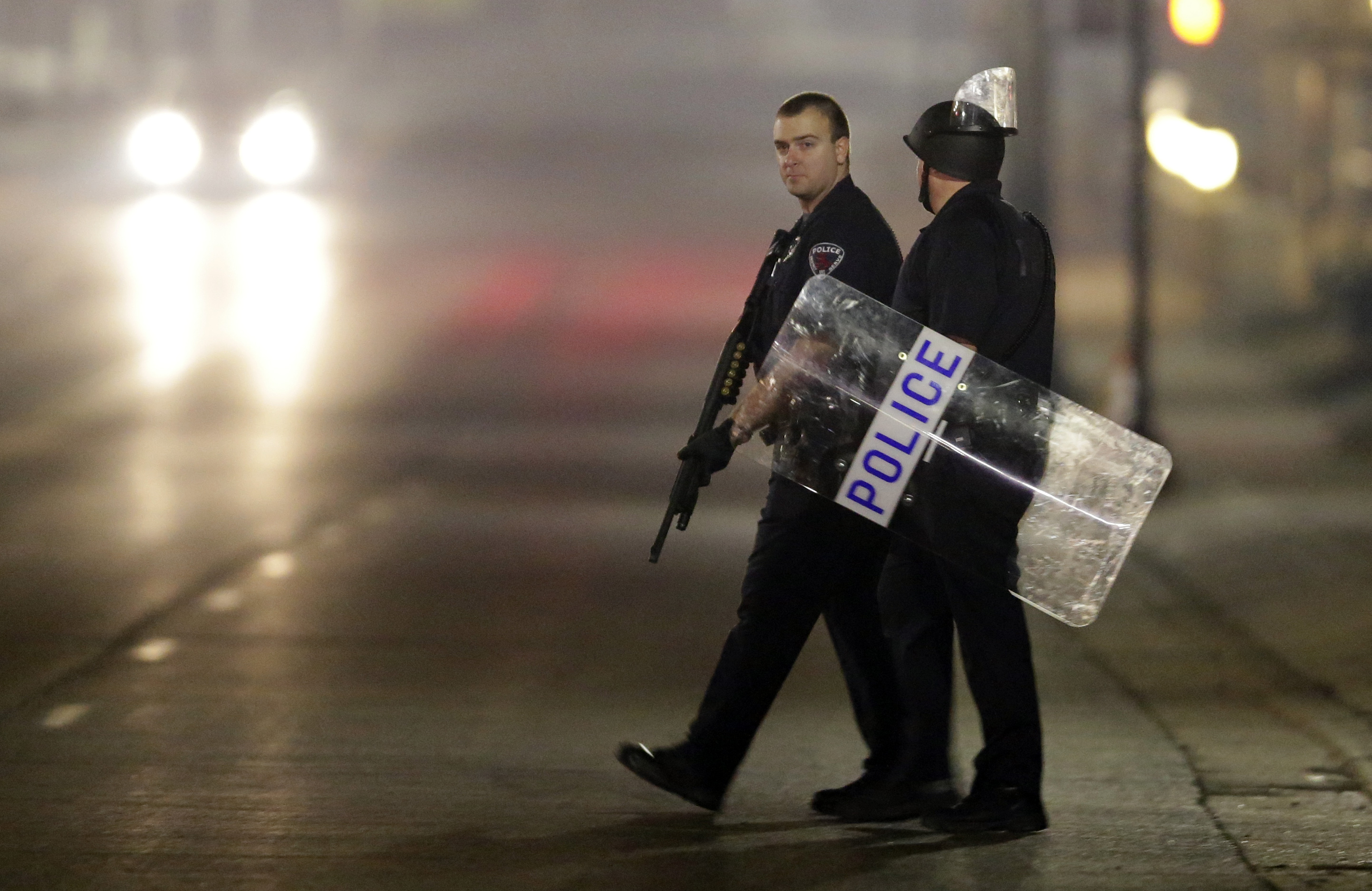 Police canvass the area as they investigate the scene where two police officers were shot outside the Ferguson Police Department Thursday, March 12, 2015, in Ferguson, Mo. (AP/Jeff Roberson)