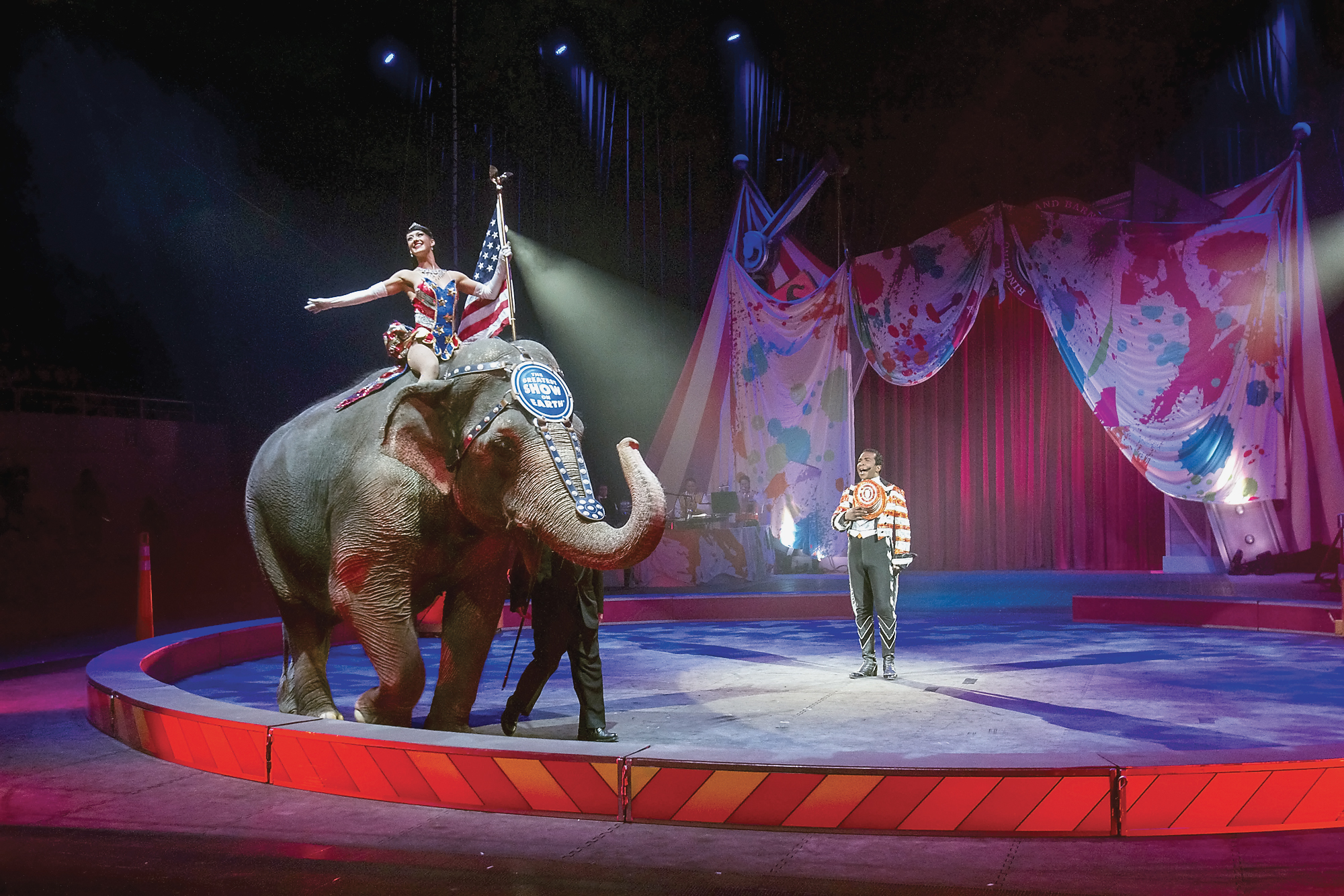 FILE - In this photo taken on Thursday, Feb. 19, 2015, ringmaster Andre McClain, center, holds his hat to his heart as the national anthem is played during the opening of the Ringling Brothers and Barnum & Bailey Circus, at Knoxville Civic Coliseum, Knoxville, Tenn.  The circus will phase out the show's iconic elephants from its performances by 2018, telling The Associated Press exclusively on Thursday, March 5, 2015 that growing public concern about how the animals are treated led to the decision. (AP Photo/The Daily Times, Mark A. Large) MANDATORY CREDIT (AP)