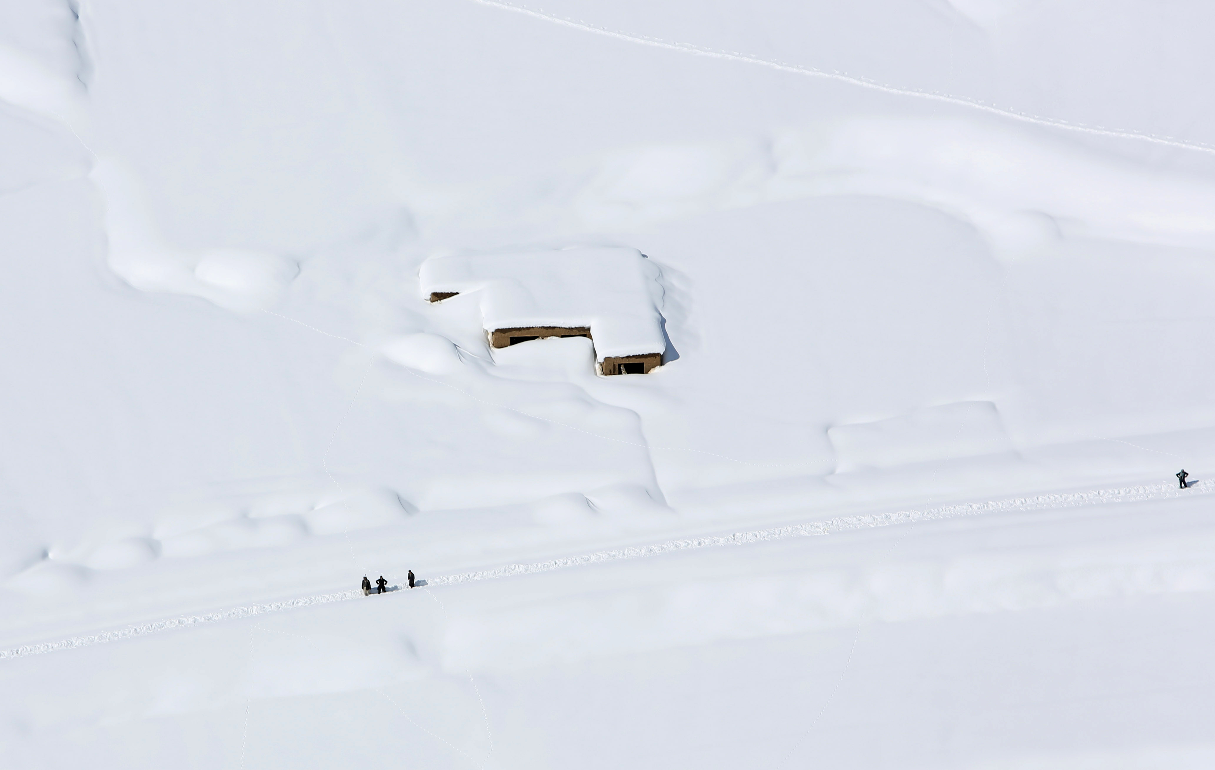 FILE - In this Friday, Feb. 27, 2015 file photo, a house is covered with snow from an avalanche in the Paryan district of Panjshir province, north of Kabul, Afghanistan. The death toll from severe weather that caused avalanches and flooding across much of Afghanistan has jumped to more than 200 people, and the number is expected to climb with cold weather and difficult conditions hampering rescue efforts, relief workers and U.N. officials said Friday. (AP Photo/Rahmat Gul, File) (AP)