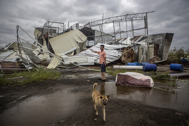 A man stands in front of a factory building that was destroyed by Typhoon Rammasun, in Leizhou, Guangdong province, China, July 19, 2014. (Reuters)