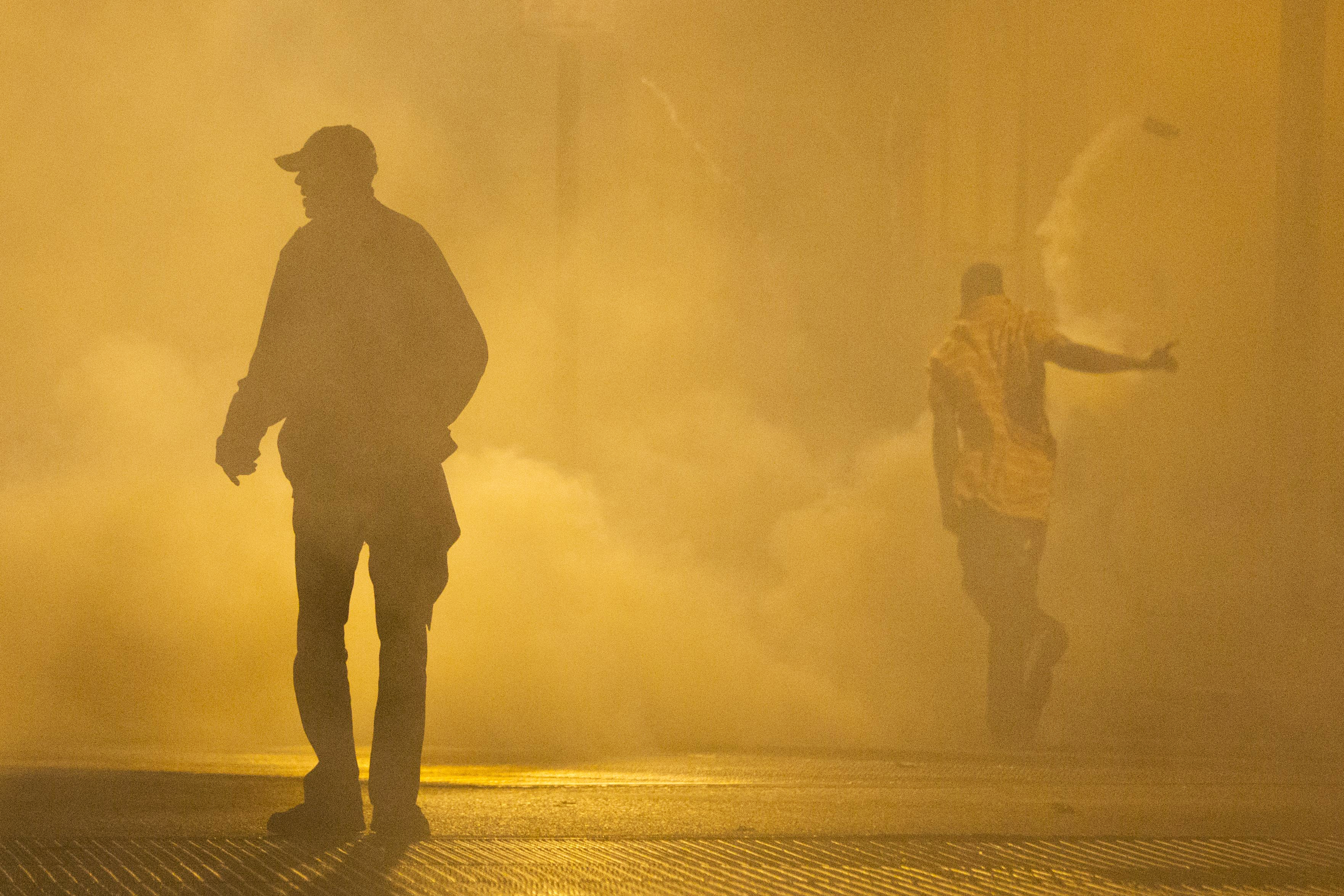 Protestors walk through smoke Tuesday, April 28, 2015, in Baltimore. (AP Photo/Matt Rourke) (AP)