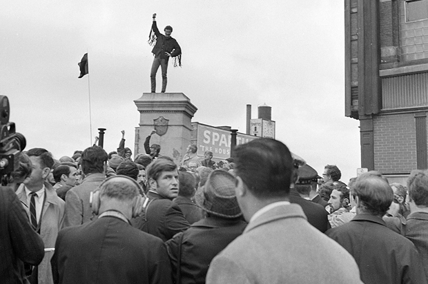 A demonstrator istands atop a pedestal from which the statue of the Haymarket Riot policeman was blasted days earlier, Chicago, Oct. 11, 1969. (AP)