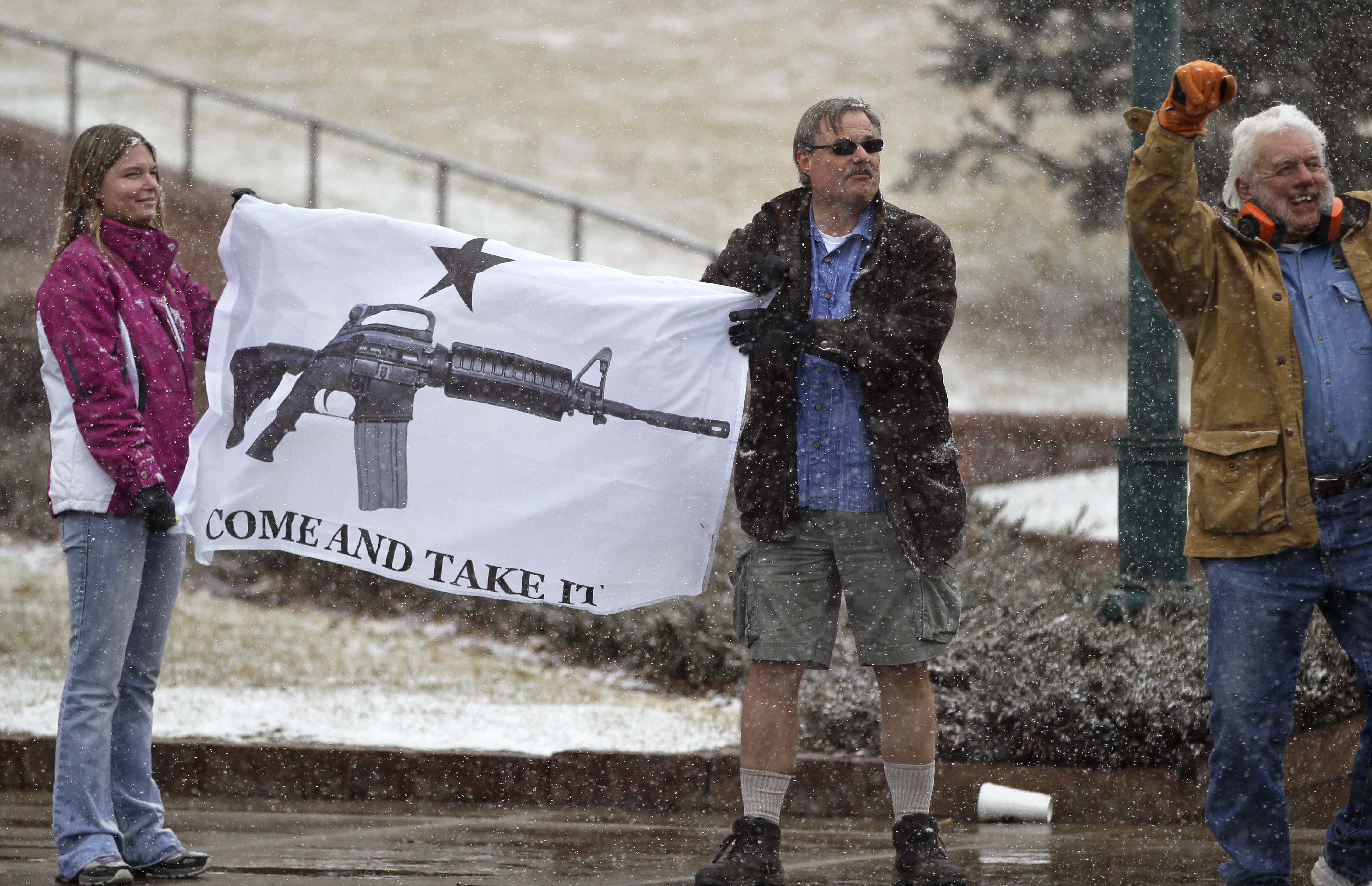 FILE - In this March 4, 2013 file photo, opponents of proposed gun control bills being considered by the Colorado Legislature hold a sign depicting an assault rifle, displaying it to those passing in cars, in front of the State Capitol, in Denver. When a gunman opened fire inside a packed movie theater in July of 2012, killing 12, it helped revive the national debate over gun control. But, as the trial of theater shooter James Holmes is scheduled to begin Monday, April 27, 2015, Colorados gun debate has quieted down. Its in a sort of gridlock, said nonpartisan Denver pollster Floyd Ciruli. (AP Photo/Brennan Linsley, file) (AP)
