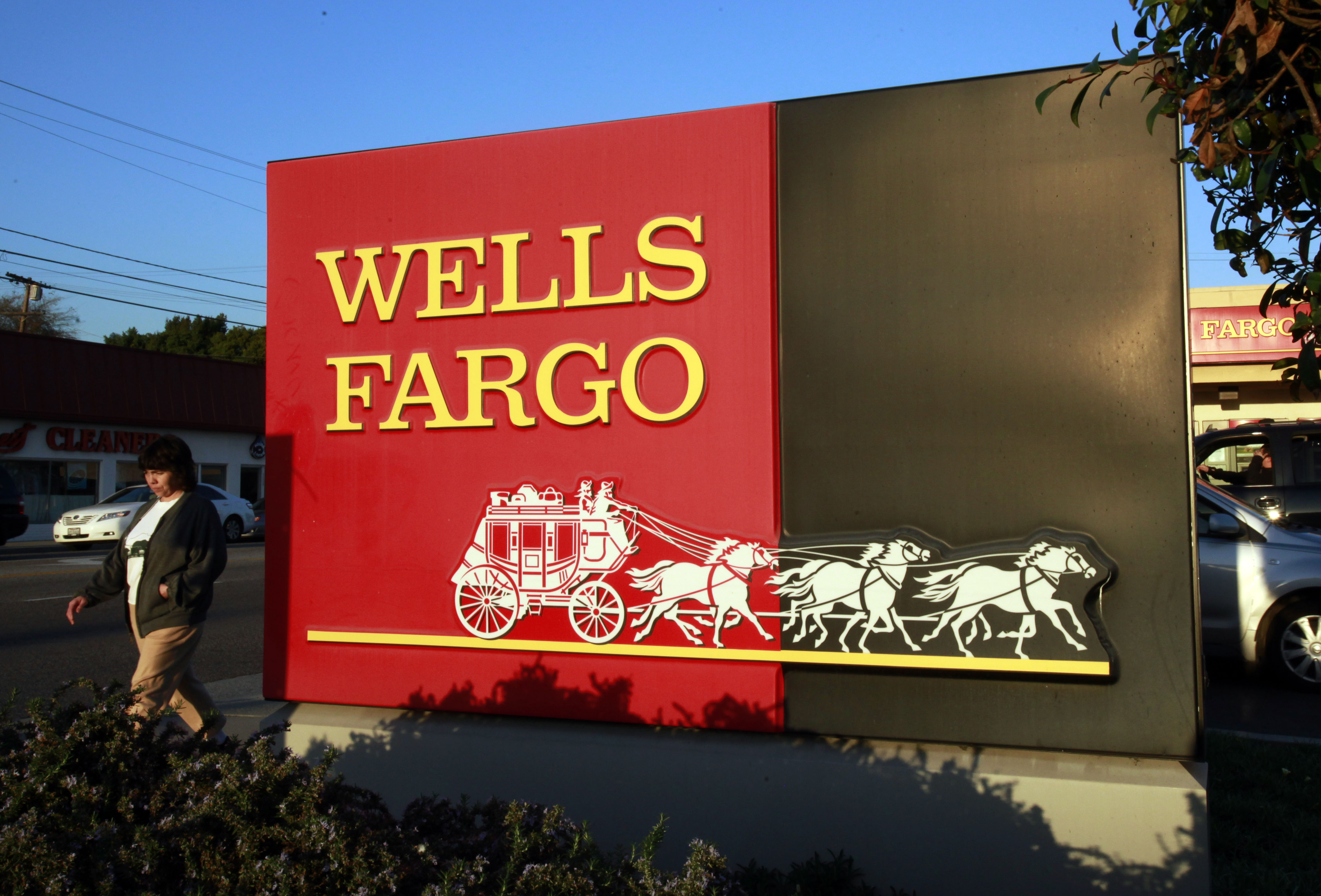 FILE - In this Jan. 18, 2011 file photo, a pedestrian walks by a Wells Fargo bank branch in Los Angeles. (AP)