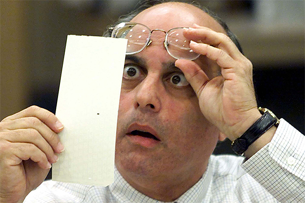 Broward County Canvassing Board member Judge Robert Rosenberg stares at a dimpled punchcard ballot November 23, 2000 during the recount of the 2000 presidential election. (Reuters/Colin Braley)