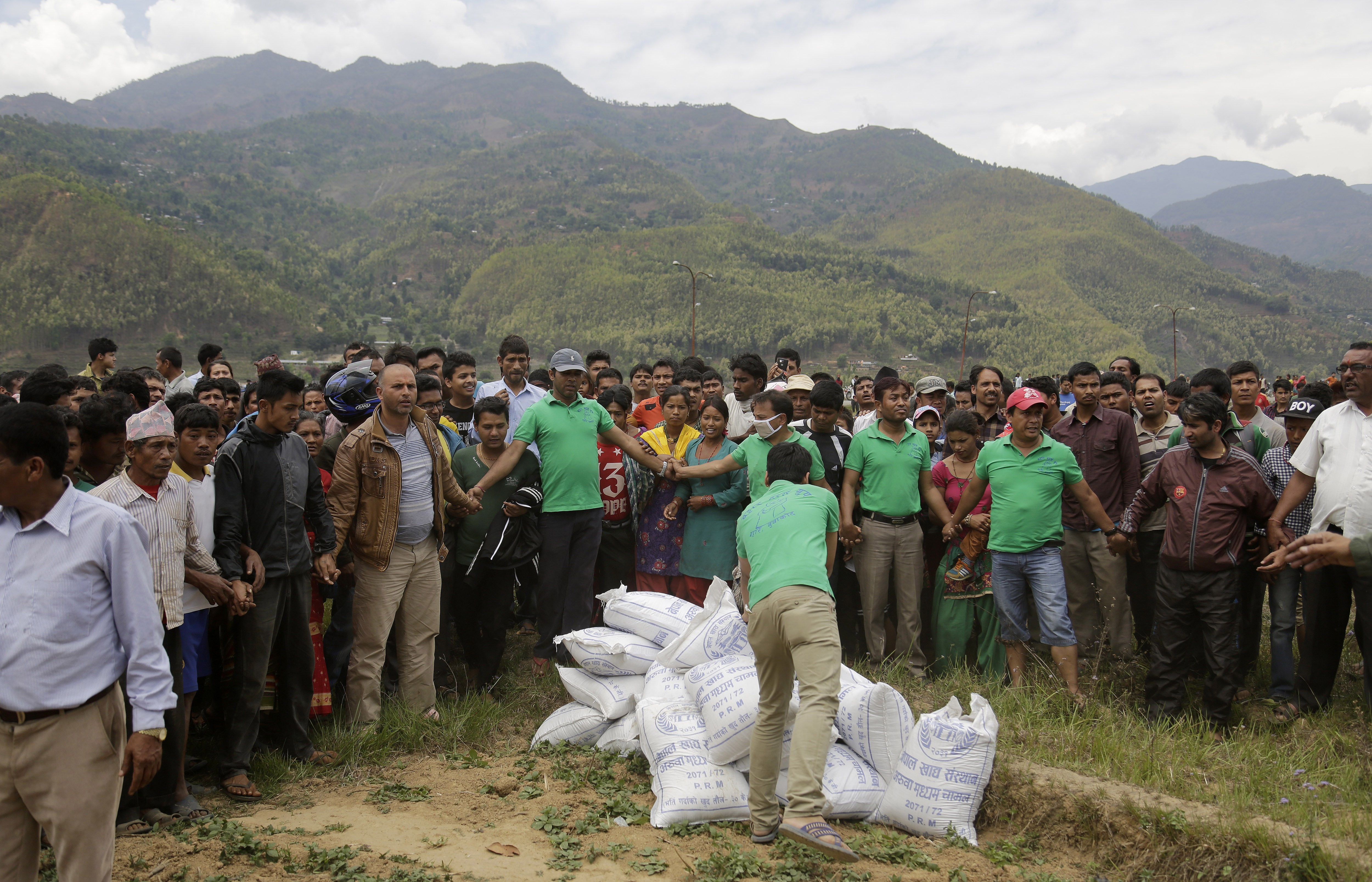 Nepalese volunteers unload relief material brought in an Indian air force helicopter for victims of Saturdays earthquake at Trishuli Bazar in Nepal, Monday, April 27, 2015. The death toll from Nepal's earthquake is expected to rise depended largely on the condition of vulnerable mountain villages that rescue workers were still struggling to reach two days after the disaster.  (AP Photo/Altaf Qadri) (AP)