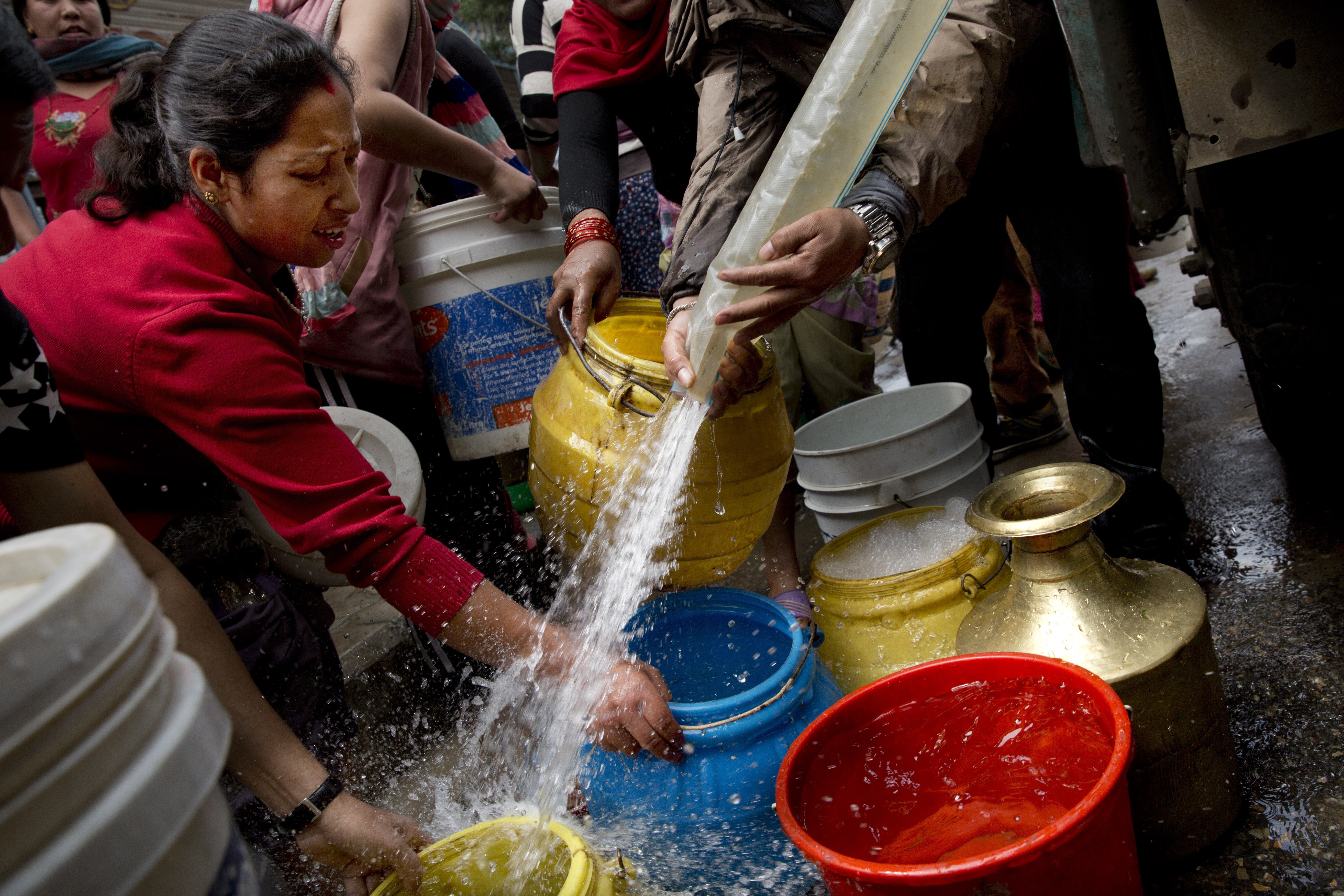 Nepalese collect water distributed in a tanker in Kathmandu, Nepal, Wednesday, April 29, 2015. While many villages across Nepal affected by Saturdays earthquake are still waiting for rescue and relief teams, life in the capital, Kathmandu, is slowly returning to normal. (AP Photo/Bernat Amangue) (Bernat Armangue)