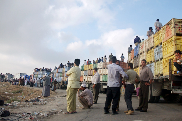 Palestinians wait in line with their vehicles to pass through the Abu Holi checkpoint in the central Gaza Strip, July 3, 2004. (AP/Hatem Moussa)