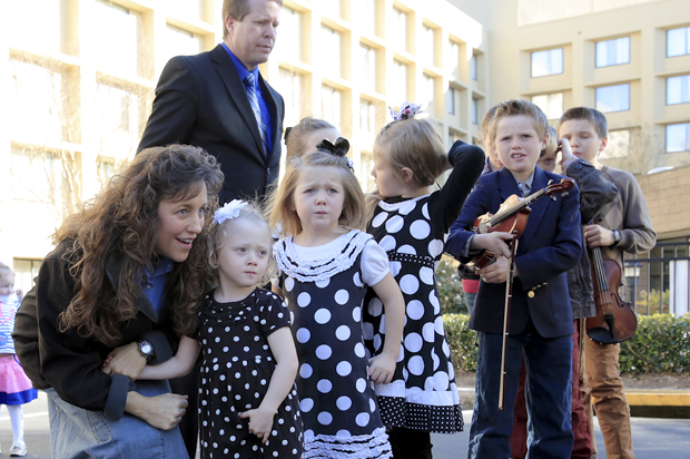 Michelle Duggar, kneeling, and Jim Bob Duggar, back right, and many of the Duggar's 19 children, in Raleigh, N.C., March 14, 2014. (AP/Ted Richardson)