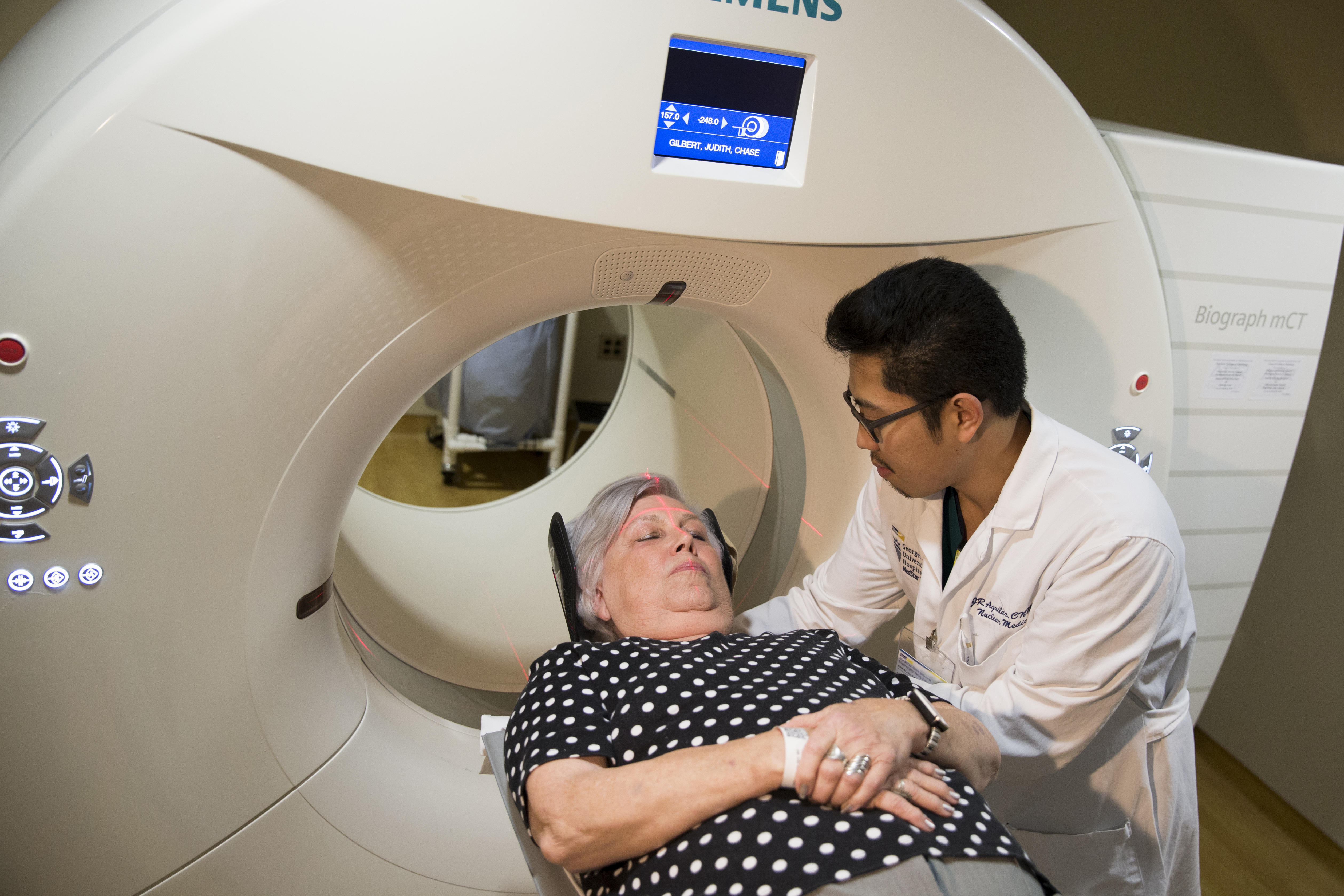 In this photo taken May 19, 2015, Judith Chase Gilbert, of Arlington, Va., is loaded into a PET scanner by Nuclear Medicine Technologist J.R. Aguilar at Georgetown University Hospital in Washington. Gilbert shows no signs of memory problems but volunteered for a new kind of scan as part of a study peeking into healthy brains to check for clues about Alzheimer's disease.  (AP Photo/Evan Vucci) (AP)