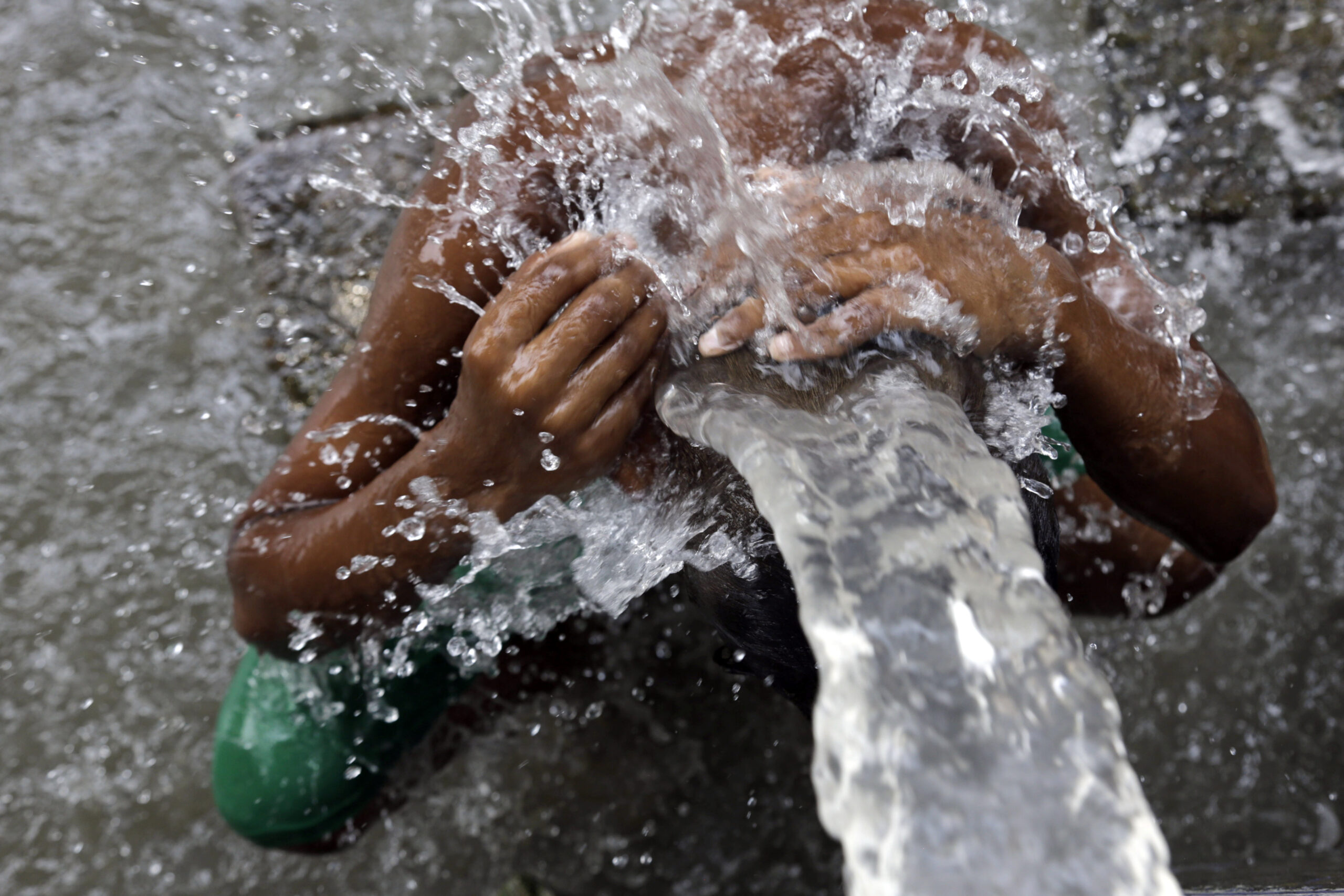 An Indian man bathes in water from a roadside tap in Kolkata, India, Sunday, May 31, 2015. Heat-related conditions, including dehydration and heat stroke, have killed more than 2,000 people since mid-April in the southern Indian states of Andhra Pradesh and Telangana, according to state officials. (AP Photo/ Bikas Das) (Bikas Das)