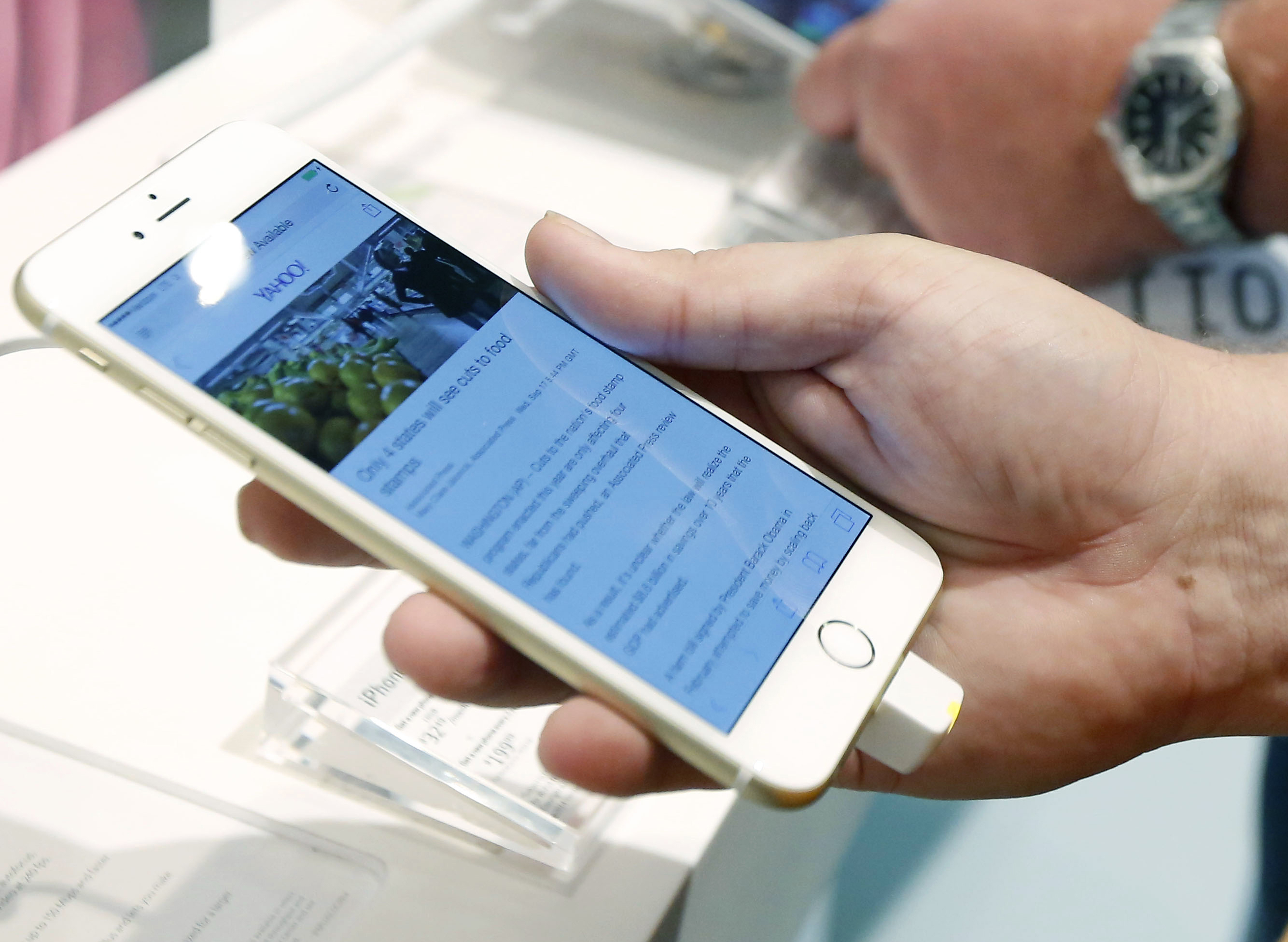 FILE - In this Sept. 19, 2014 file photo, a customer looks at the screen size on the new iPhone 6 Plus while waiting in line to upgrade his iPhone at a Verizon Wireless store in Flowood, Miss. A newly-discovered glitch in Apple's software can cause iPhones to mysteriously shut down when they receive a certain text message. (AP Photo/Rogelio V. Solis, File) (AP)