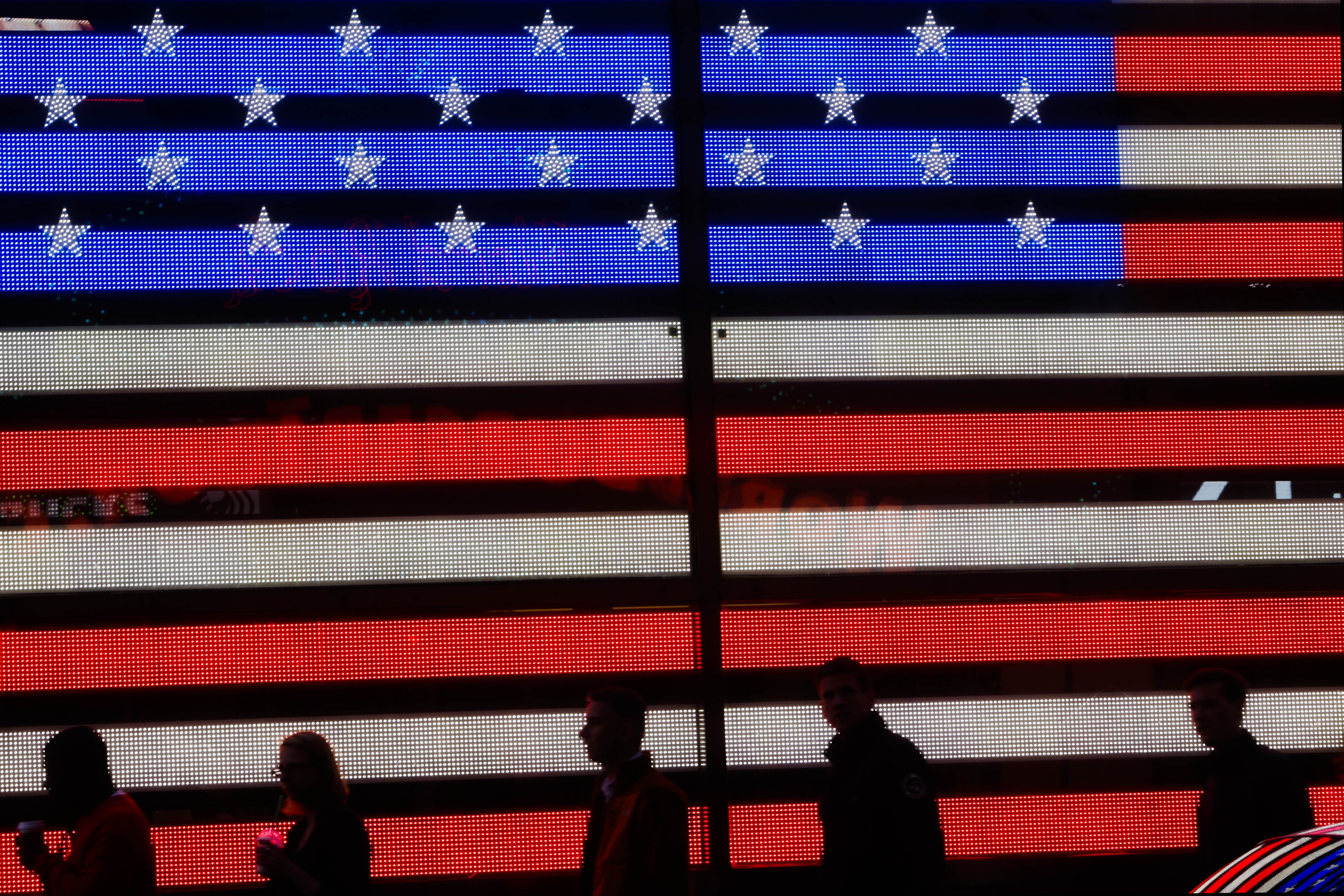 Pedestrians walk past a light display of a U.S. flag in Times Square in New York on Saturday, May 23, 2015. (AP Photo/Frank Franklin II) (AP)