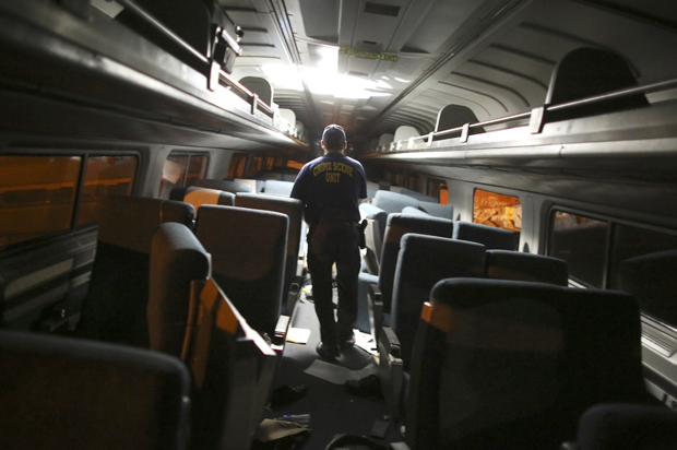 A crime scene investigator looks inside a train car after a train wreck, Tuesday, May 12, 2015, in Philadelphia. (AP/Joseph Kaczmarek)