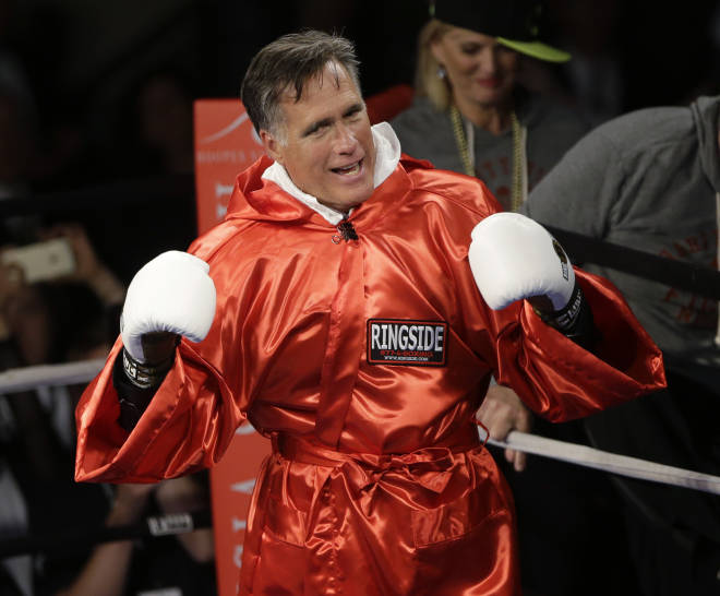 Former Republican presidential candidate Mitt Romney raises his gloves before sparring with five-time heavyweight boxing champion Evander Holyfield during a charity fight night event (AP Photo/Rick Bowmer)