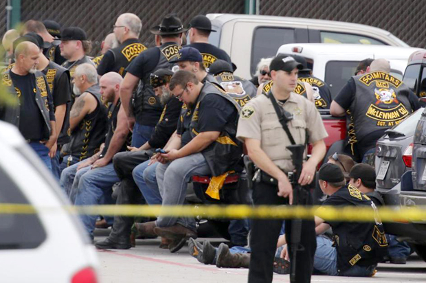 A McLennan County deputy stands guard near a group of bikers in the parking lot of a Twin Peaks restaurant, May 17, 2015, in Waco, Texas. (AP/Rod Aydelotte)