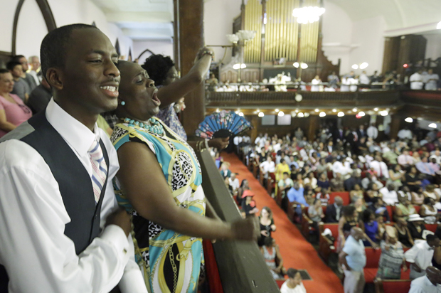 Parishioners Shakur Francis, left, and Karen Watson-Fleming sing at the Emanuel A.M.E. Church Sunday, June 21, 2015, in Charleston, S.C. (AP/David Goldman)