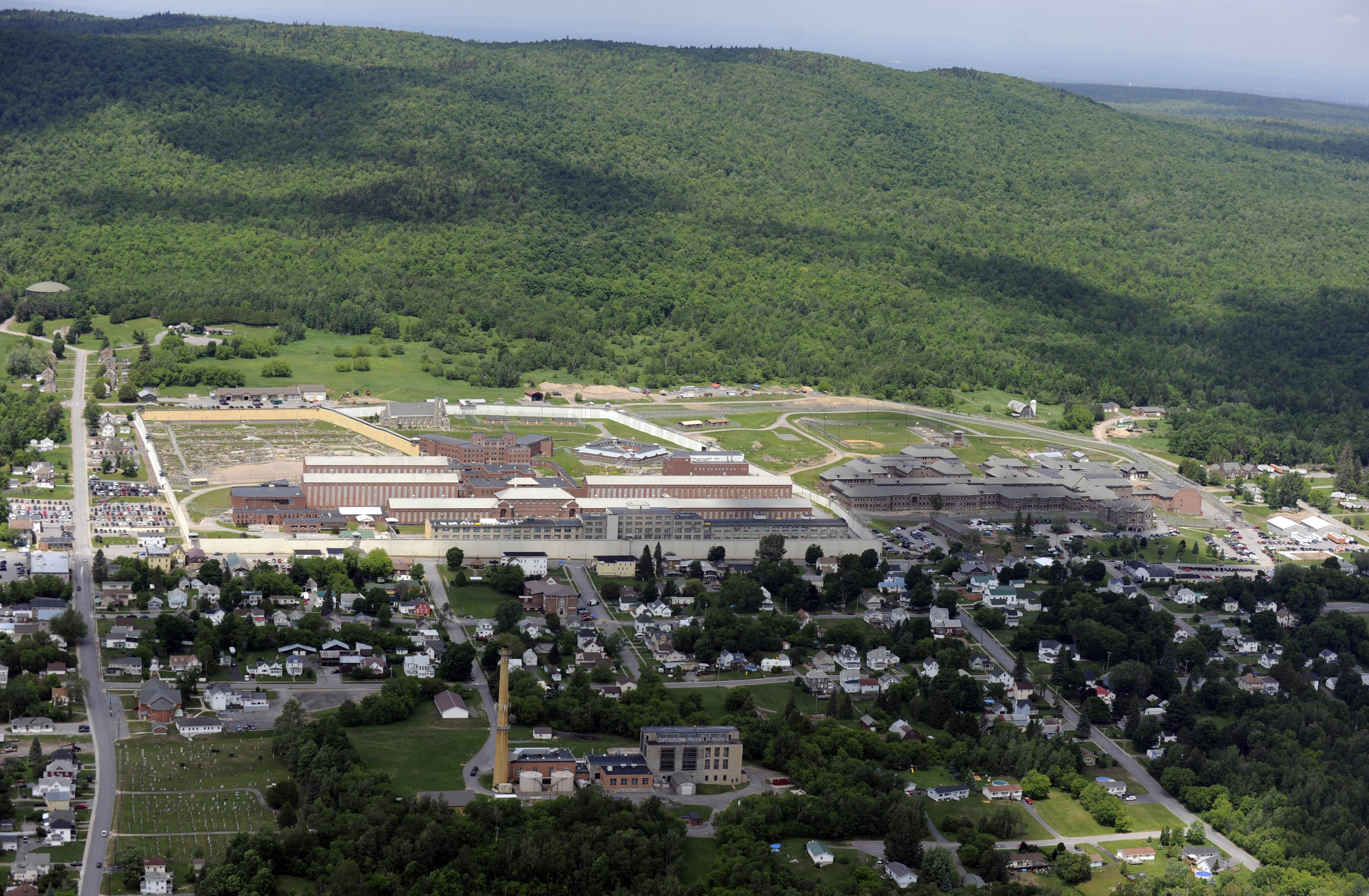 This aerial photo shows the Clinton Correctional Facility on Thursday, June 11, 2015 in Dannemora, N.Y. Police continue to search for David Sweat, 34, and Richard Matt, 48, two escaped inmates from the correctional facility.  In a renewed burst of activity near the prison, police using dogs and helicopters blocked off a main road and concentrated their sixth day of searching Thursday on a swampy area just a couple of miles from the institution, situated about 20 miles (30 kilometers) from the Canadian border. (AP Photo/Tim Roske) (AP)