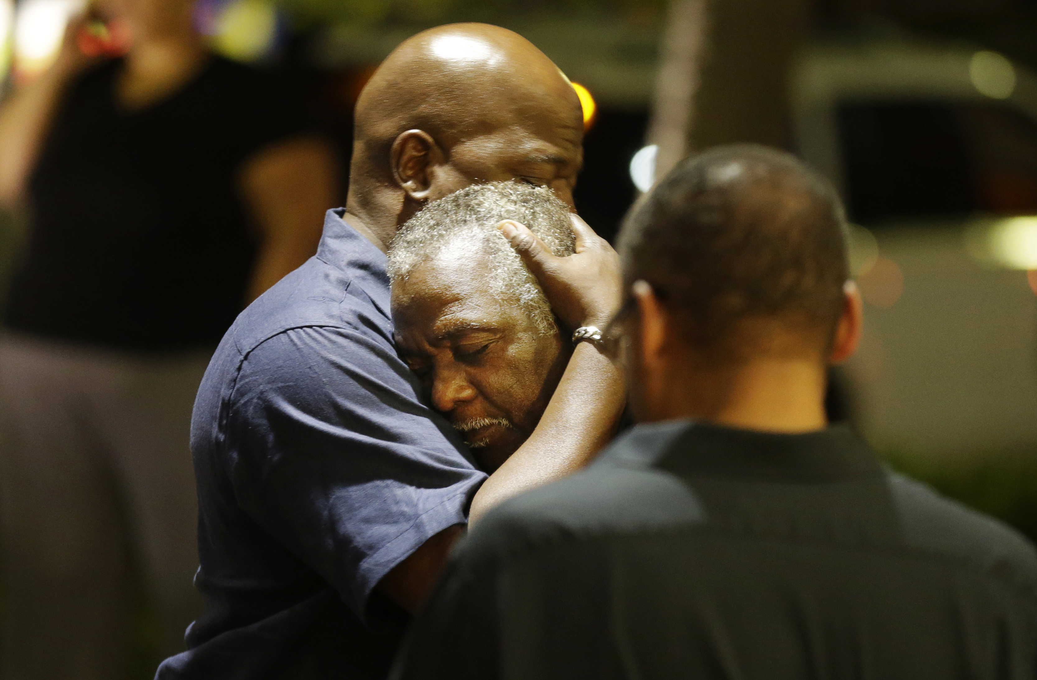 Worshippers embrace following a group prayer across the street from the scene of a shooting Wednesday, June 17, 2015, in Charleston, S.C. (AP Photo/David Goldman) (AP)